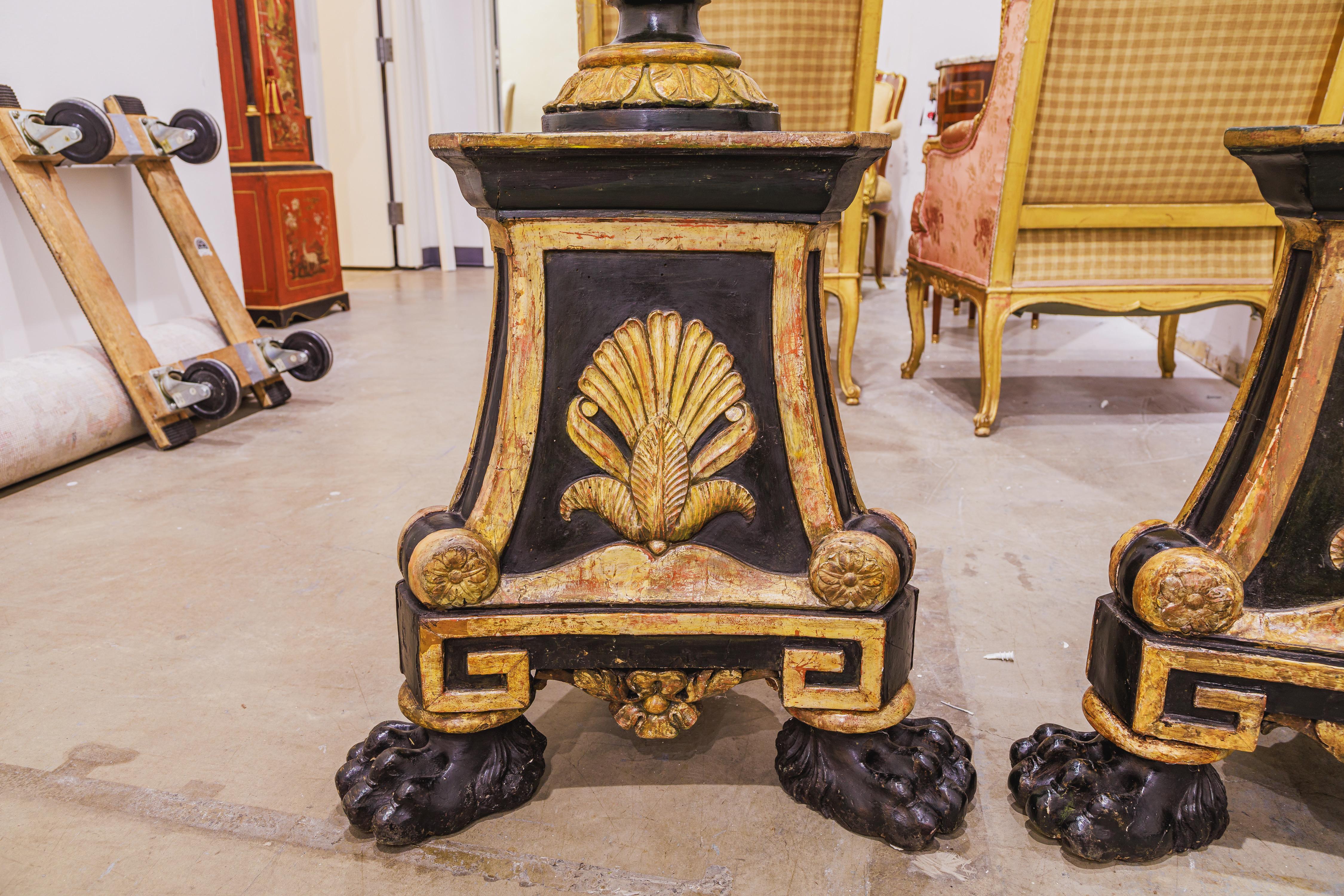A large and fine pair of Italian Renaissance carved and black painted torchieres with parcel gilt. 