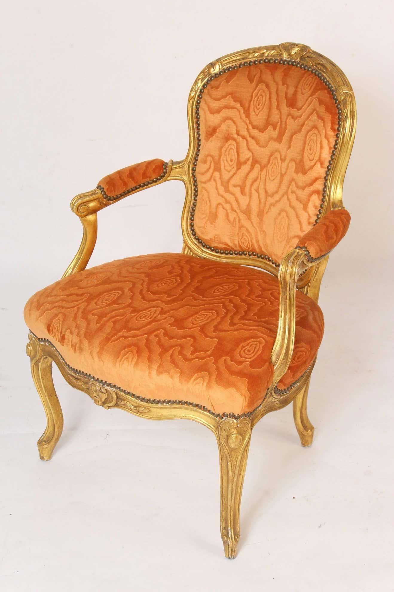A fine pair of petite French 19th century Louis XV style carved and gilt open armchairs.