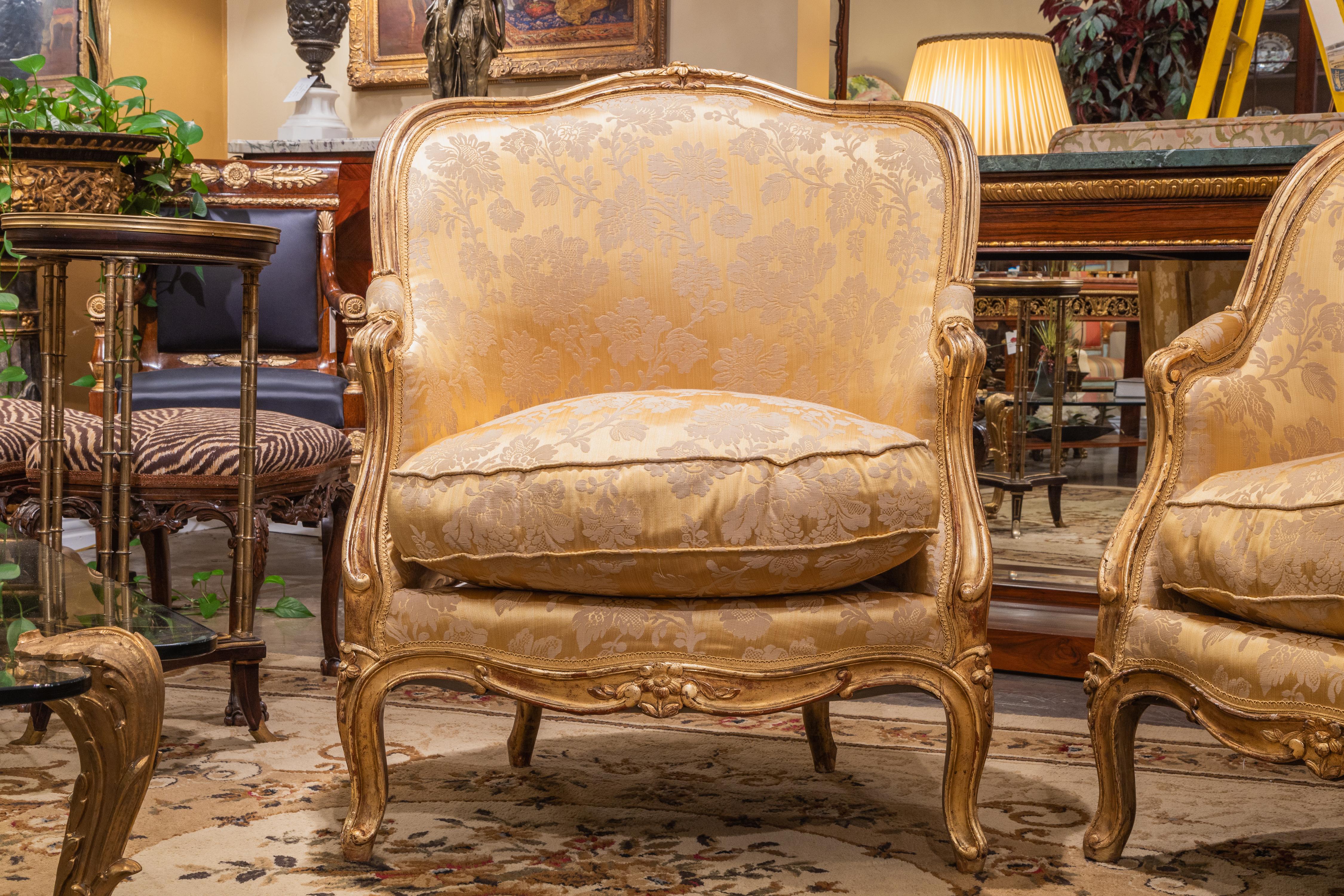 A very fine pair of Louis XV water gilt and large French bergere's. Custom silk upholstery. Water gilt still evident with the original gilding .