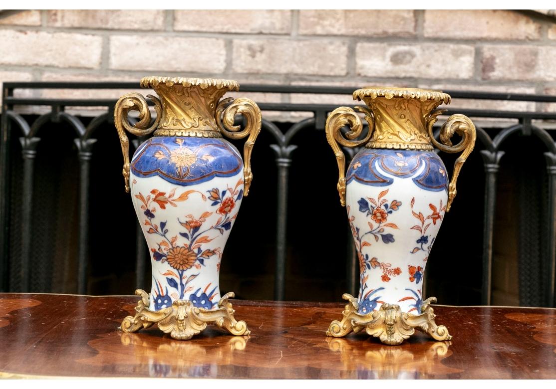 Paire de vases de forme balustre en porcelaine décorée Imari, en bronze doré et ornementé. 
Magnifiquement monté avec des montures en bronze doré de style rococo, avec des poignées en forme de plumes. 

Condit : Veuillez voir les photos détaillées. 