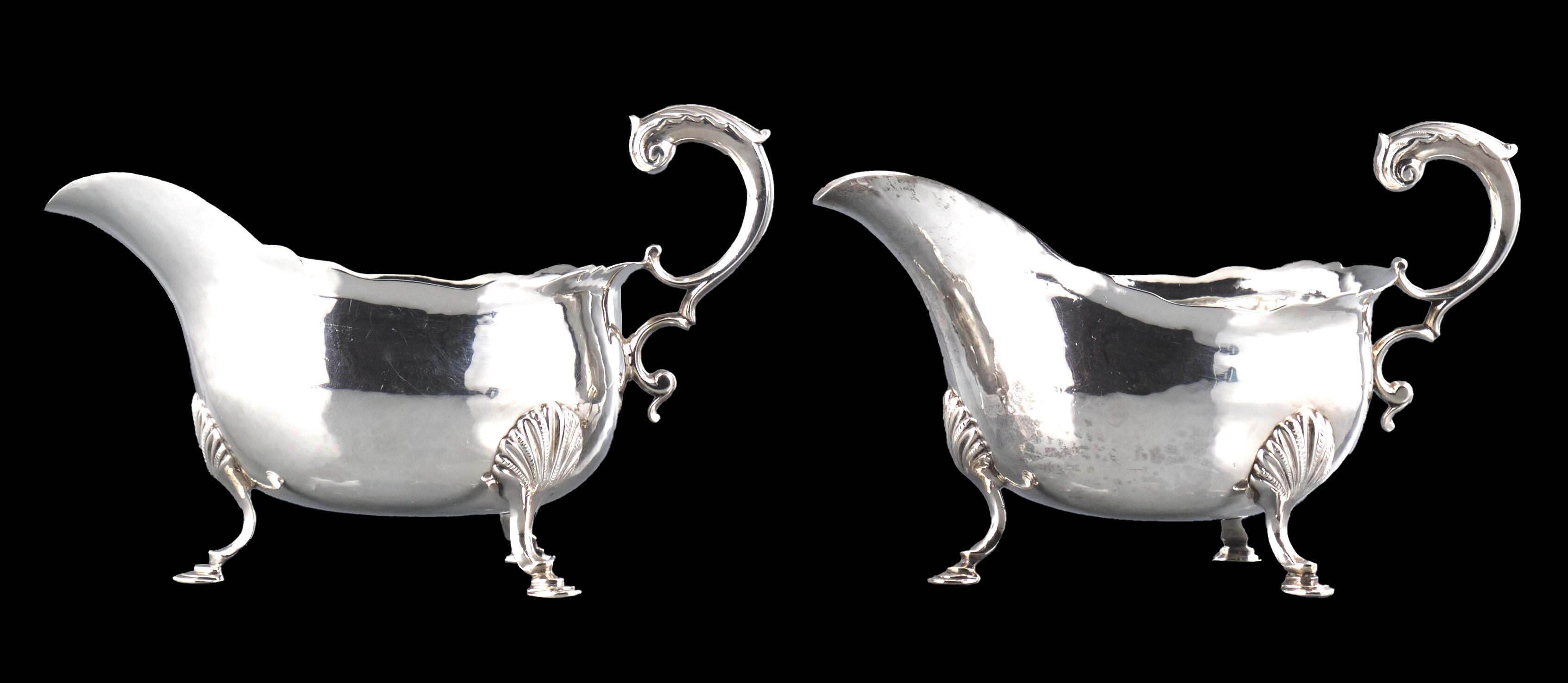 A very handsome and fine pair of early George III sterling silver sauce boats, their spot hammered bellied bodies rising to wavy rims, both their fronts engraved with a Mural Crown, indicating a person of civic heraldry. 
Both fitted with foliate
