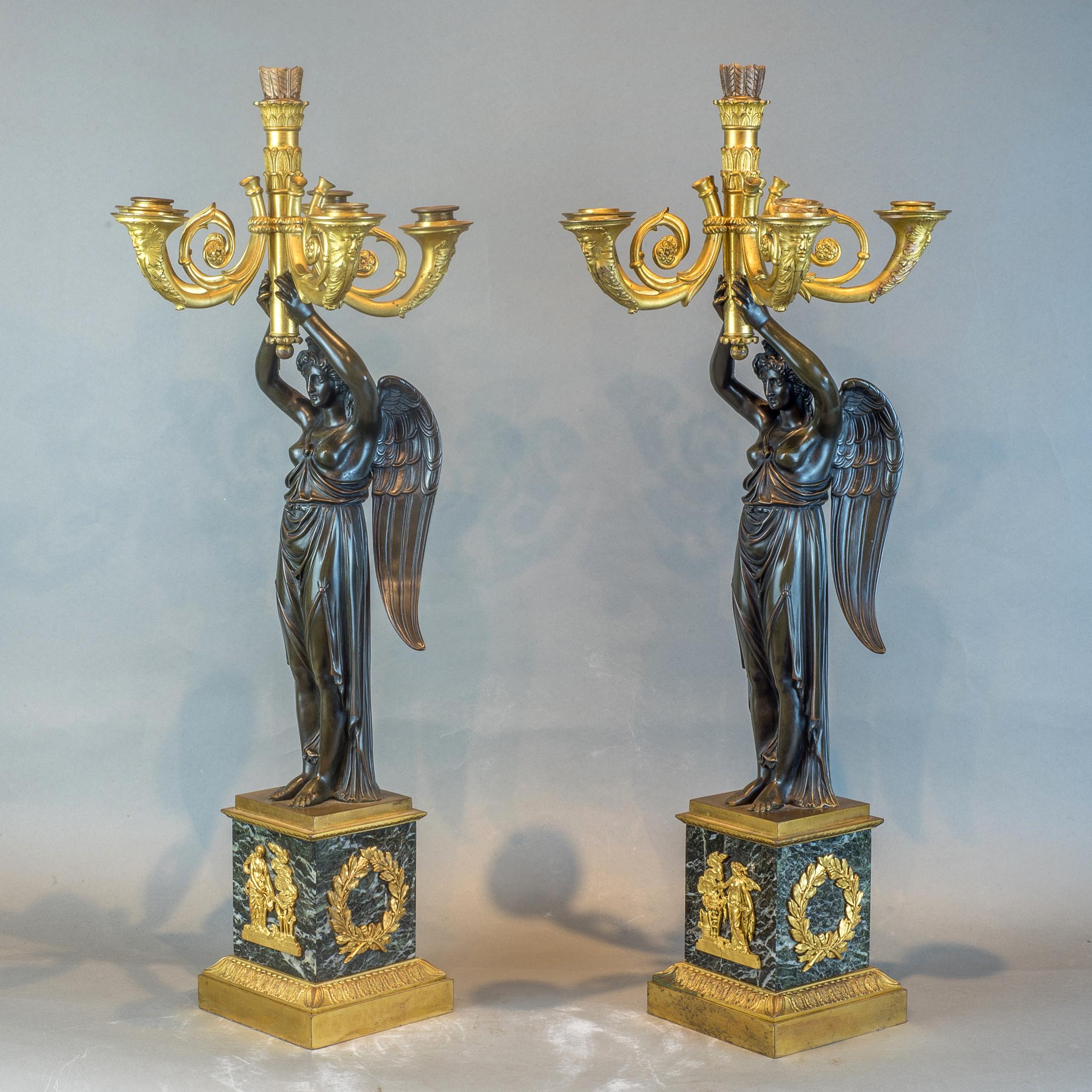 A fine pair of Empire gilt and patinated bronze, six-light figural candelabras suspended by a winged maiden on top an antique verde marble square gilt plinth.

Origin: French
Date: circa 1880
Size: 25 in. x 10 1/2 in.