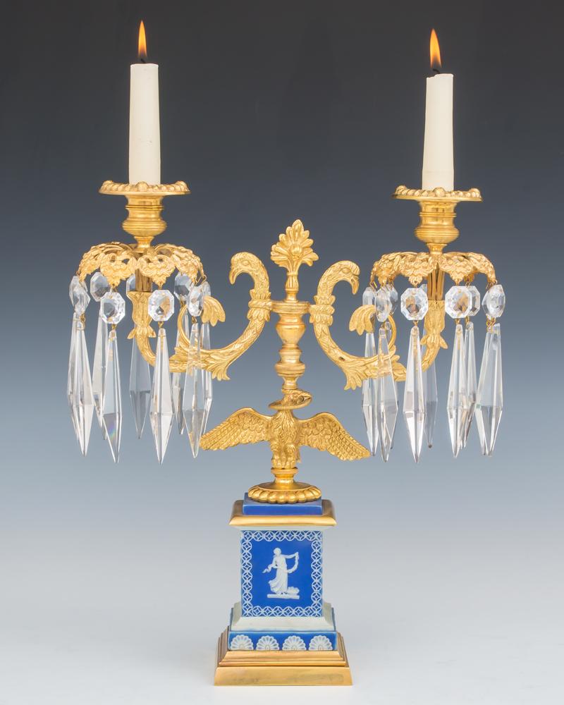 A fine pair of English regency period candelabra on unusual blue Wedgwood bases which are marked Adams the base decorated with fan arches and classic Greek figures bordered with in interlaced garlands the bases surmounted by an classic perched eagle