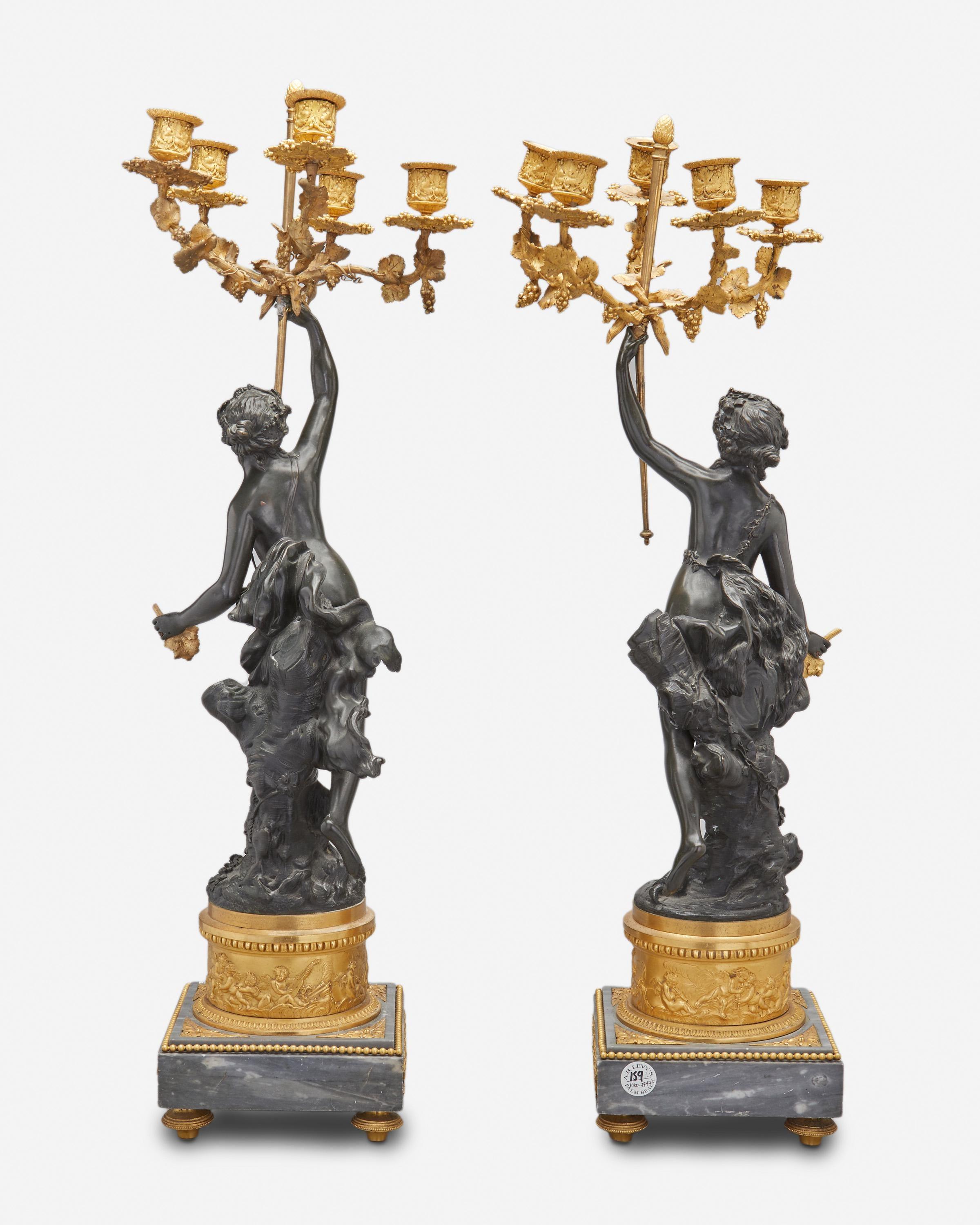 19th century pair of fine French candelabrum
 Each candelabrum in the form of a patinated bronze Bacchante holding aloft a gilt-bronze standard issuing five grapevine candle arms atop a gilt-bronze pedestal with a bas-relief putti frieze and raised