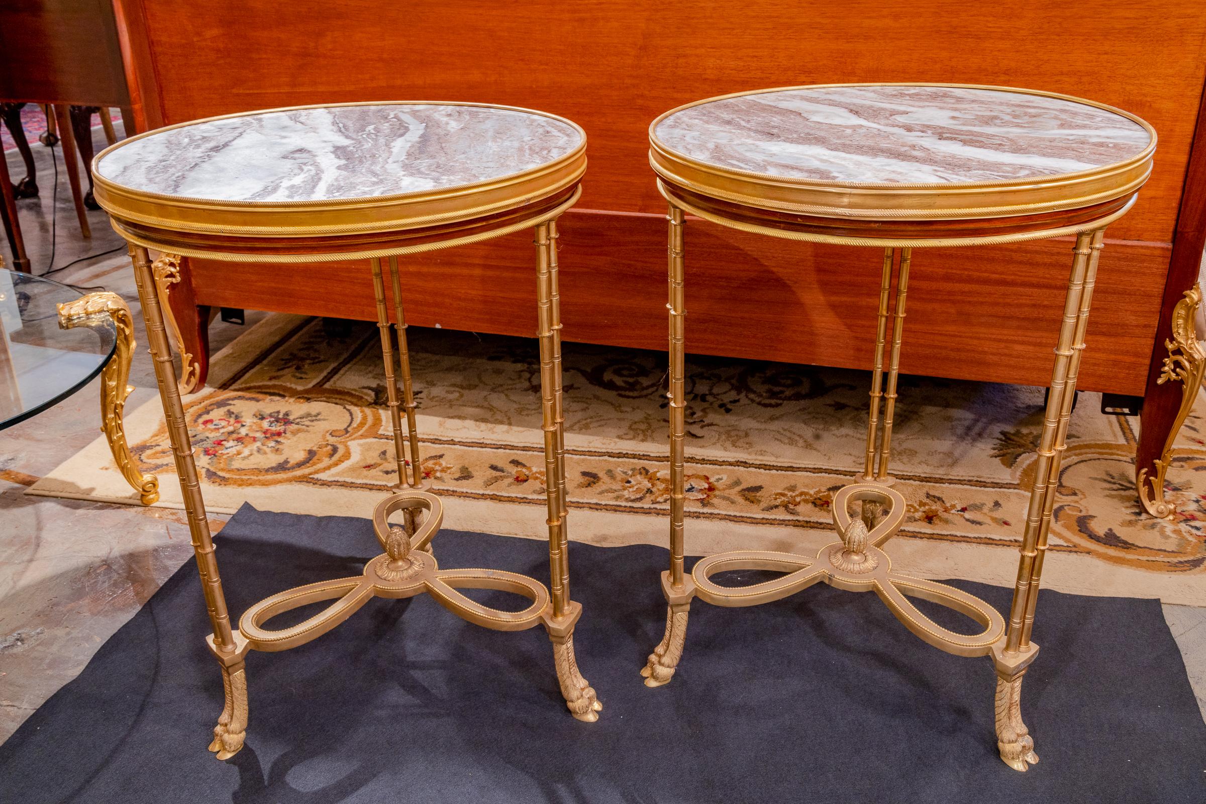 A fine pair of French mahogany and gilt bronze Empire style gueridon tables with marble tops mid 20th century.