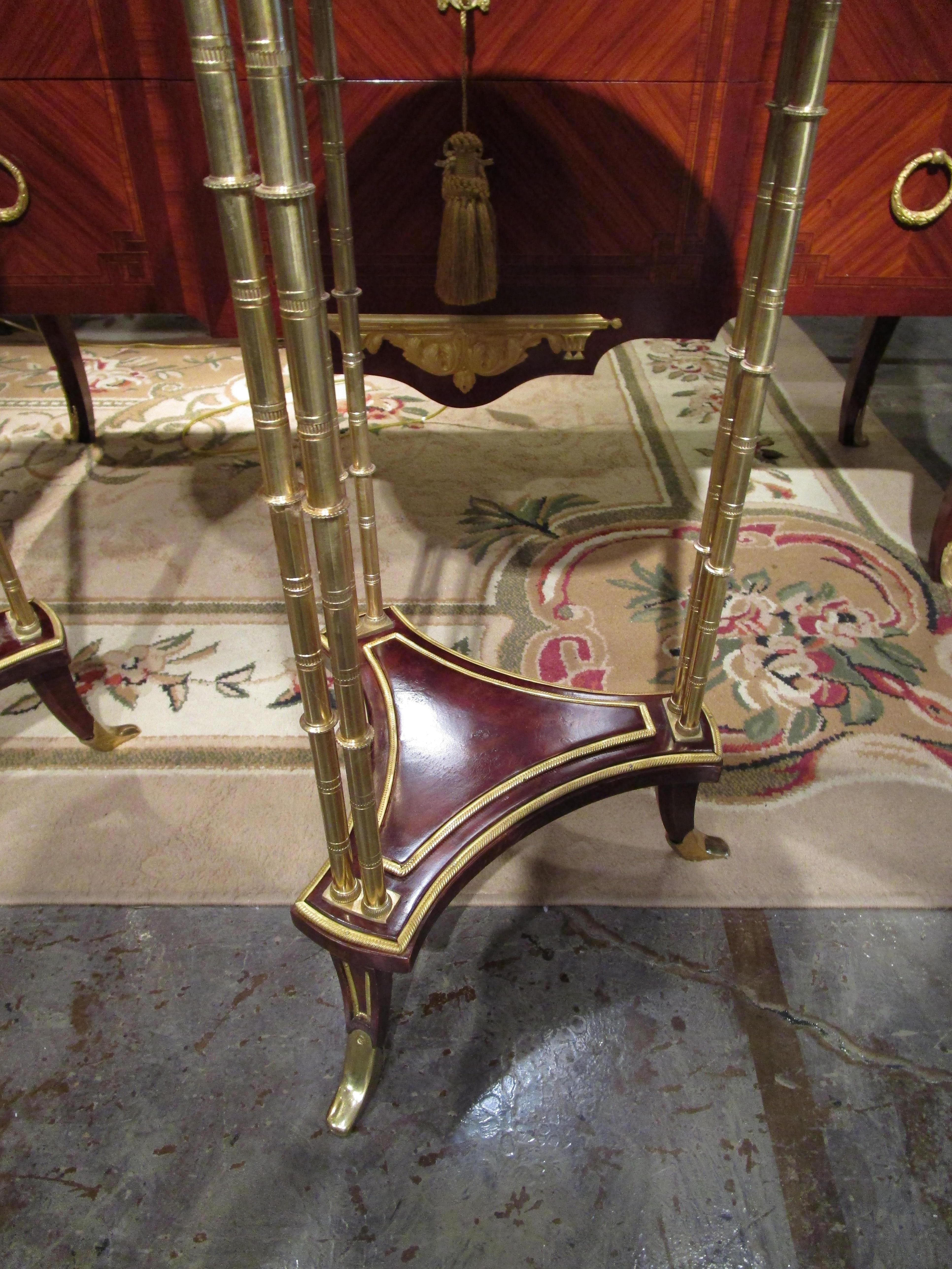 A fine pair of French Gueridon tables in the style of Adam Weisweiler. Mahogany and gilt bronze with marble tops.
