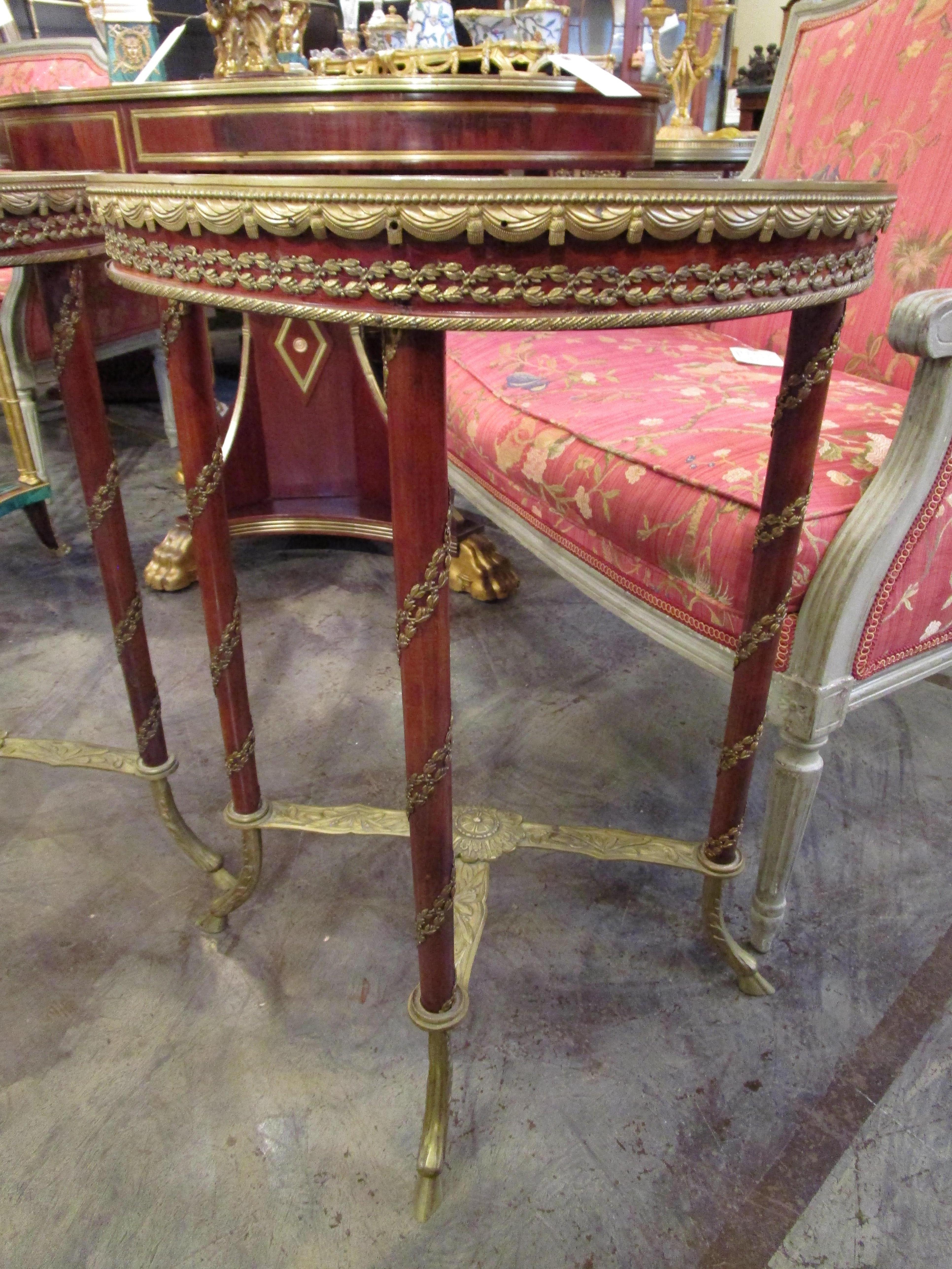 A fine pair of French mahogany and gilt bronze gueridon tables with marble tops. Fine quality.