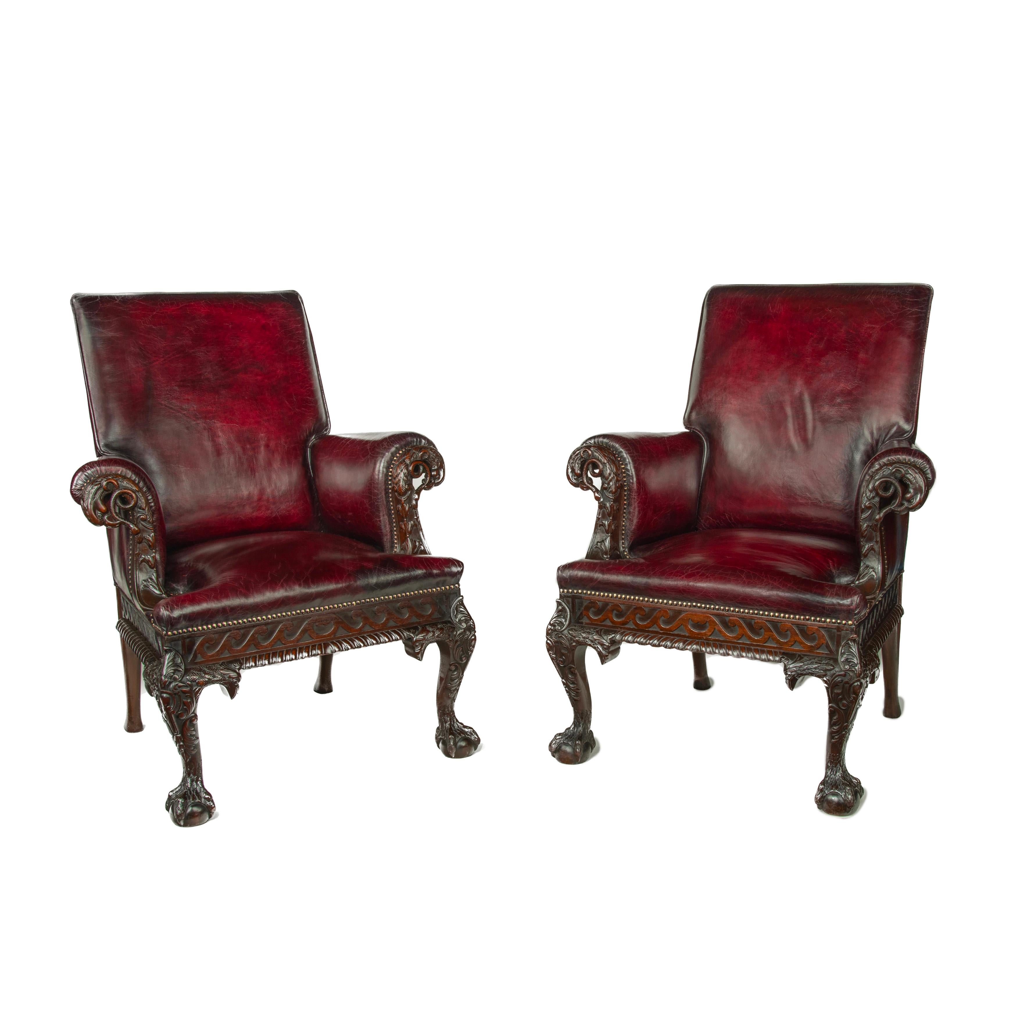 A fine pair of generous late Victorian mahogany eagle armchairs, each with a square back and scrolling armrests, the face of each arm boldly carved with an openwork eagle holding a writhing snake in its beak, above graduated flowerheads, the chair