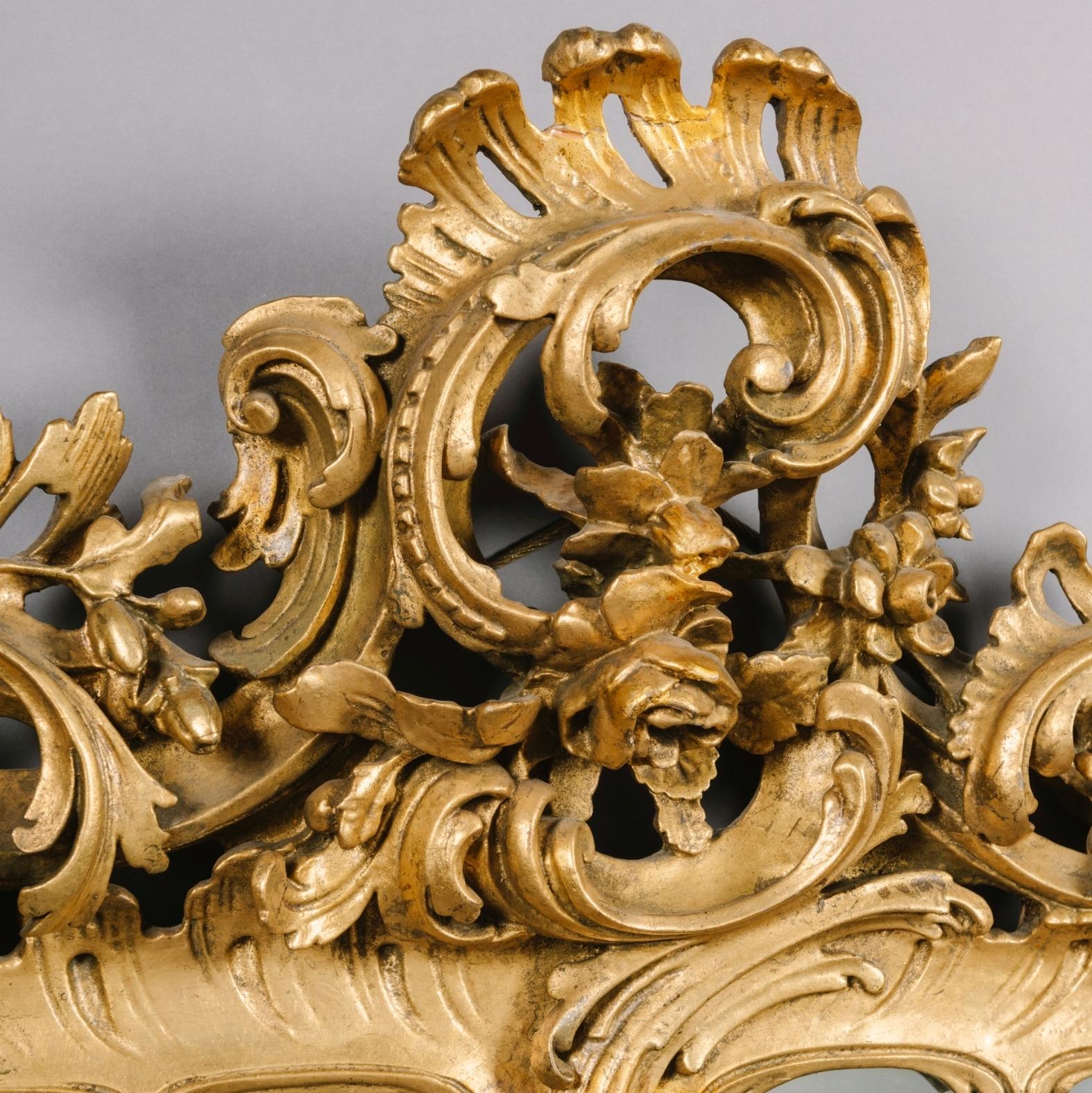 A Fine Pair of George III Style Carved Giltwood Mirrors.

Each mirror has a rectangular bevelled mirror plate within a carved giltwood frame of acanthus and 'C'-scrolls, surmounted by a pierced scrolling cresting of acanthus, oak leaves and flowers.