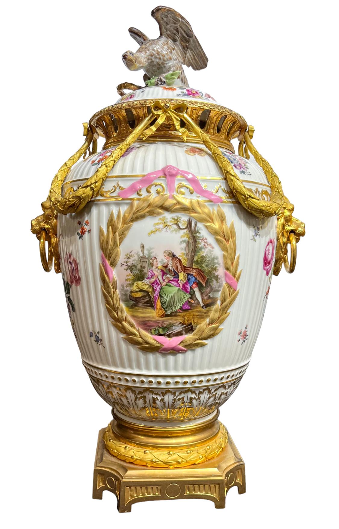 Dieses feine Paar gerippter Porzellanvasen oder Potpourri-Vasen basiert auf einem Berliner Kannelierte Porpourri-Paar. Das Paar wurde in Österreich handbemalt und für die vergoldeten bronzenen Lorbeerkränze und Löwenmaskengriffe nach Frankreich