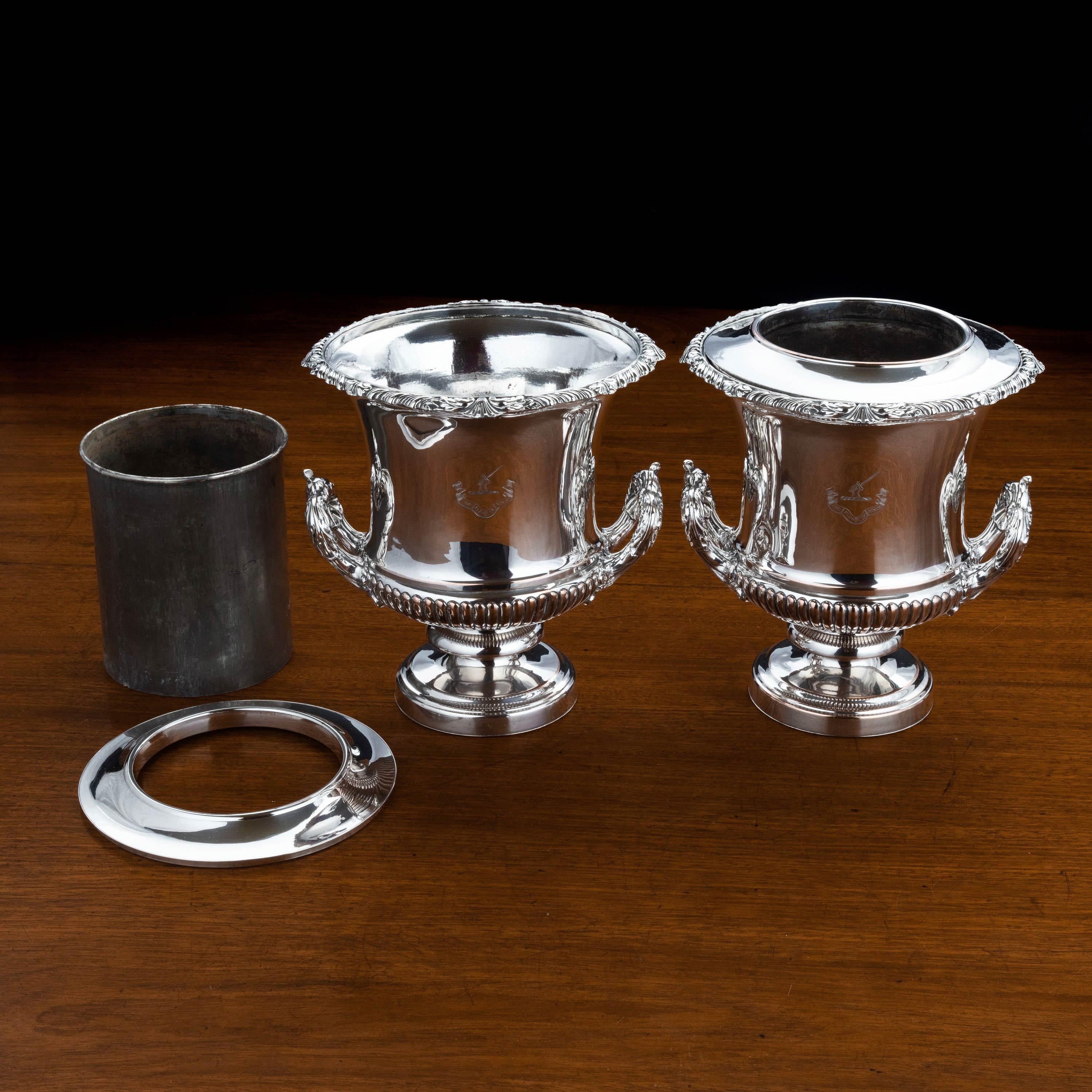 A particularly fine quality pair of Sheffield-plated champagne or wine coolers. With well-cast borders. The centre sections removable. Bearing a noble crest.
The smaller one weighs 2960g and the larger 3095g.
