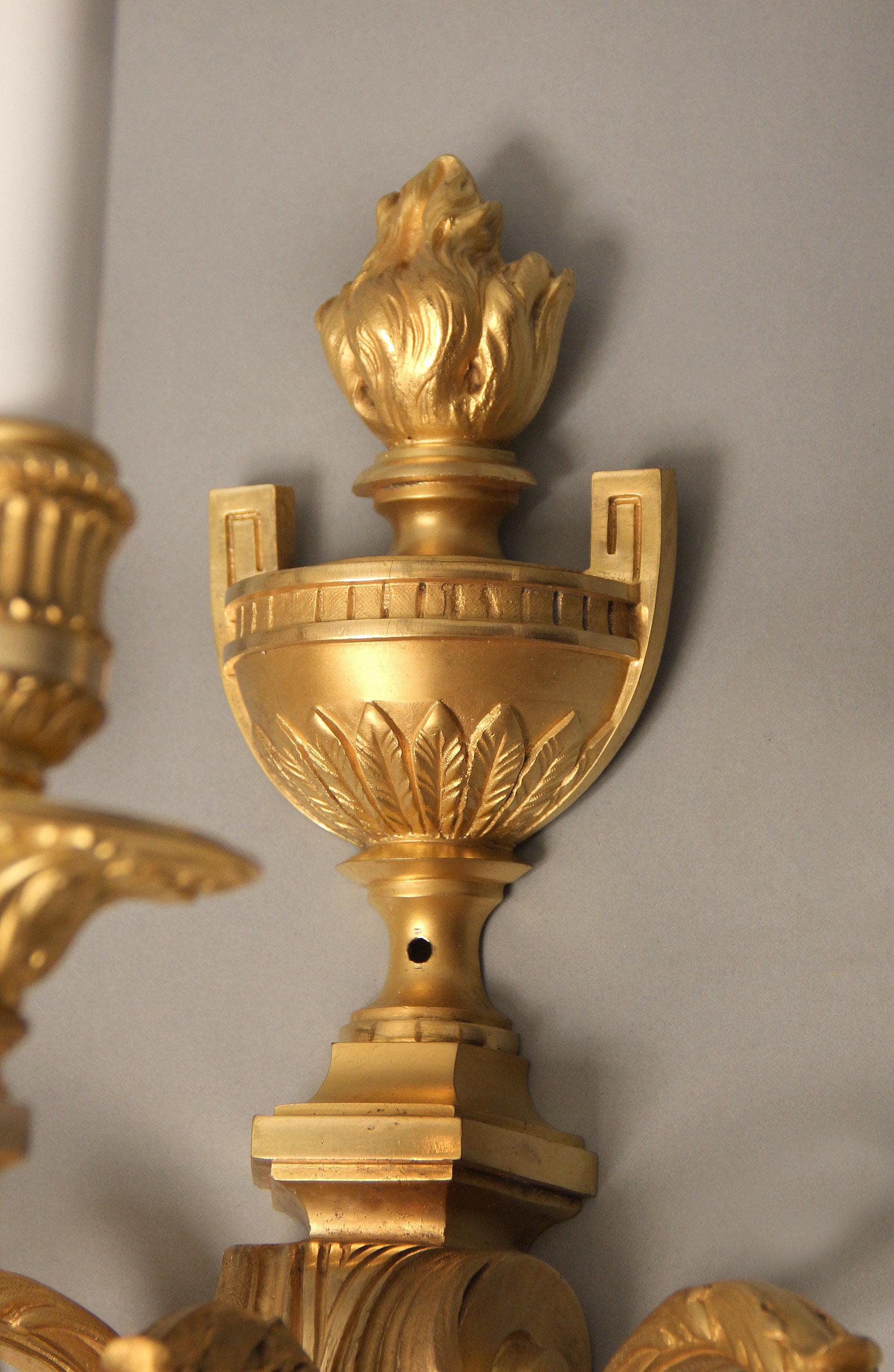 A fine pair of late 19th century gilt bronze three-light sconces

The top with a flaming urn and the beautiful designed body with a grape vine swag.