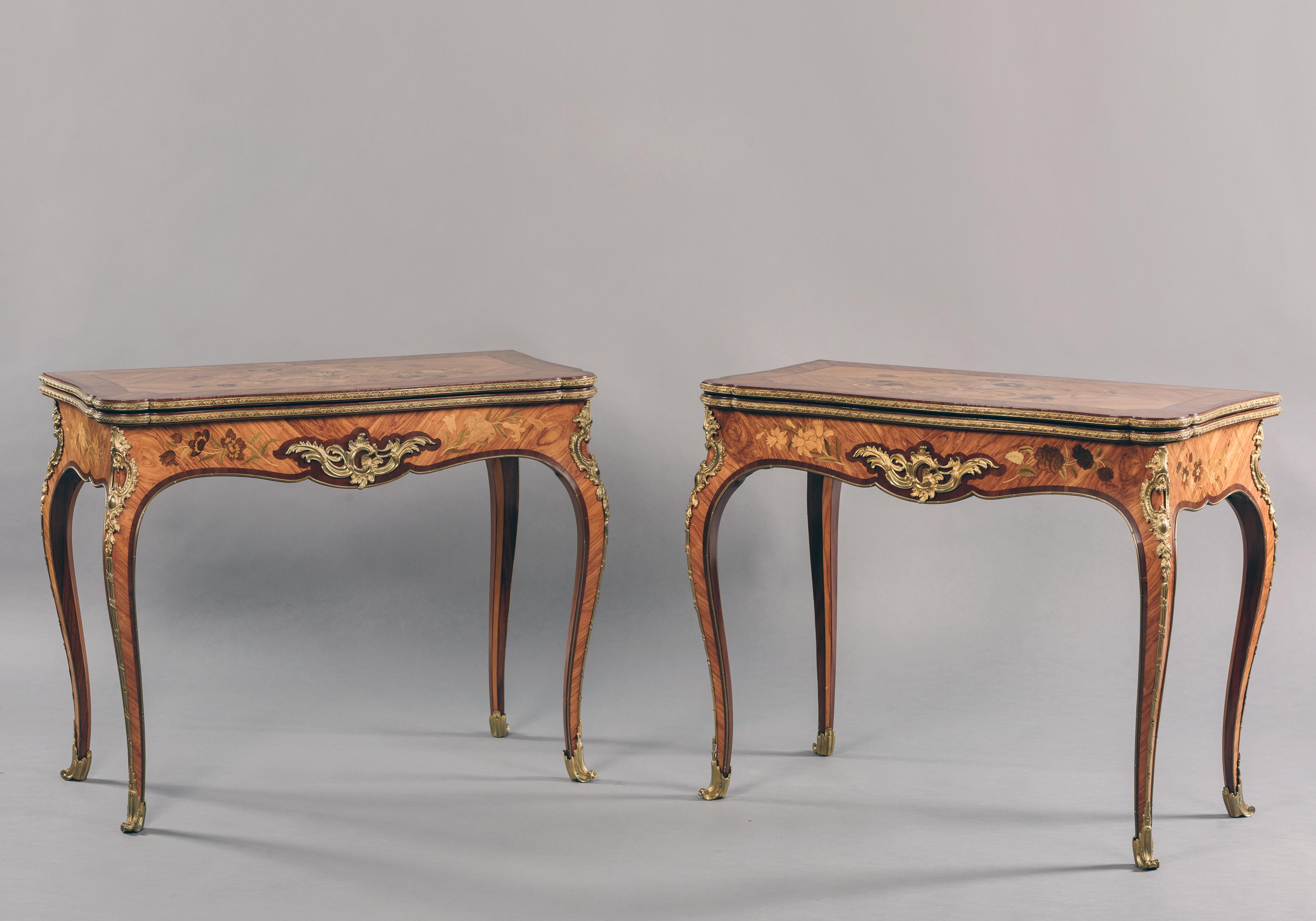 A fine pair of Louis XV style gilt bronze mounted marquetry inlaid card tables.

French, circa 1880.

Each table has a serpentine-shaped fold over top finely inlaid with marquetry depicting cornucopia and a vase issuing flowers, the top opens to