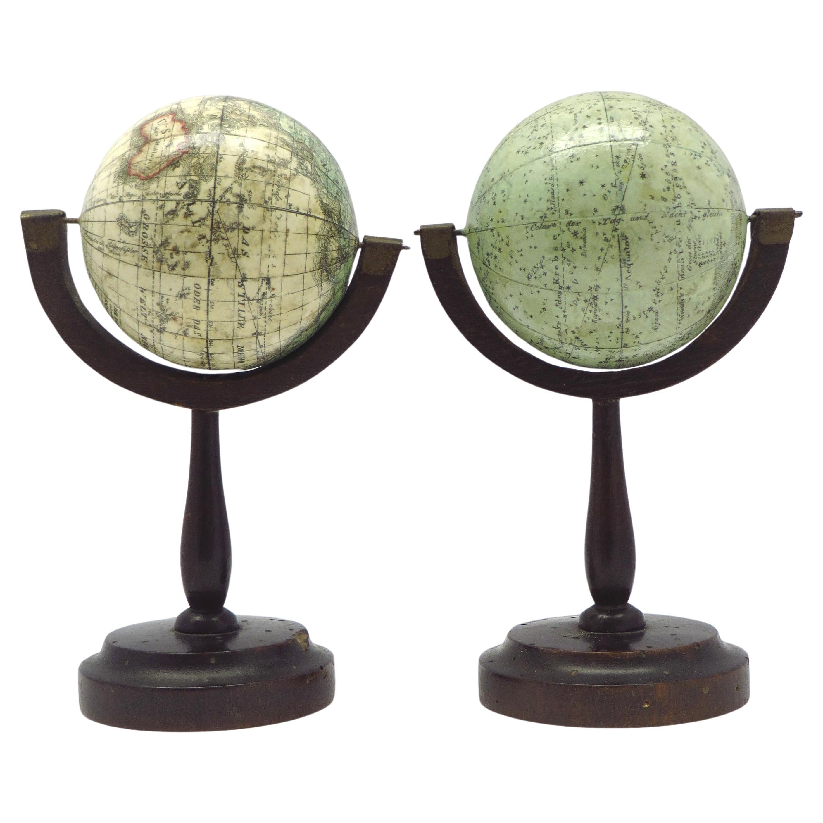 Une belle paire de globes miniatures sur des stands en vente