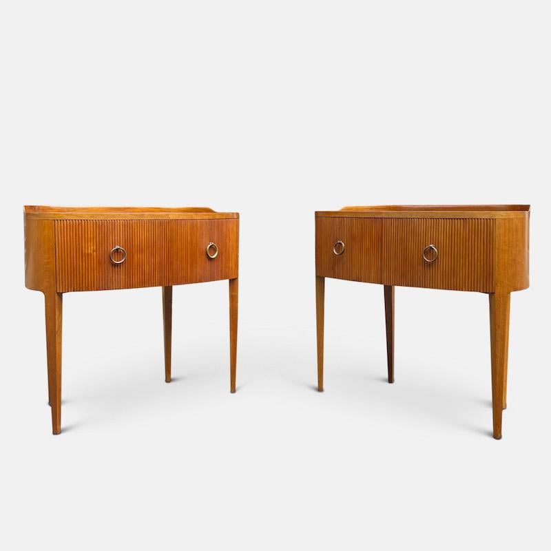 A pair of Paolo Buffa side tables circa 1940s

Designed with a beautifully curved front, the gently tapered legs frame two ridged doors with classical brass ring handles. The doors open to reveal a sycamore lined interior containing an open shelf