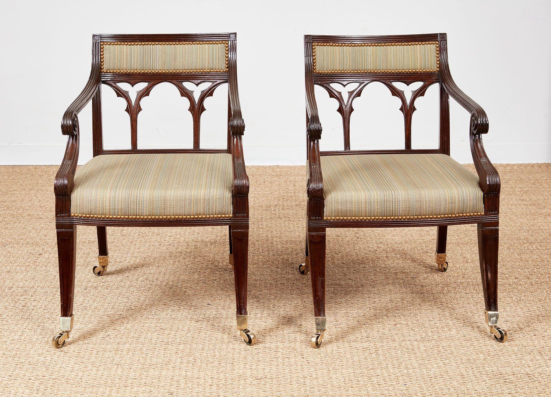 Belle paire de fauteuils Regency en acajou anglais du début du 19e siècle, avec des cadres cannelés, des dossiers rembourrés sur des panneaux de tracerie gothique, des accoudoirs à double volute, des pieds sabre moulurés et inclinés vers le bas,