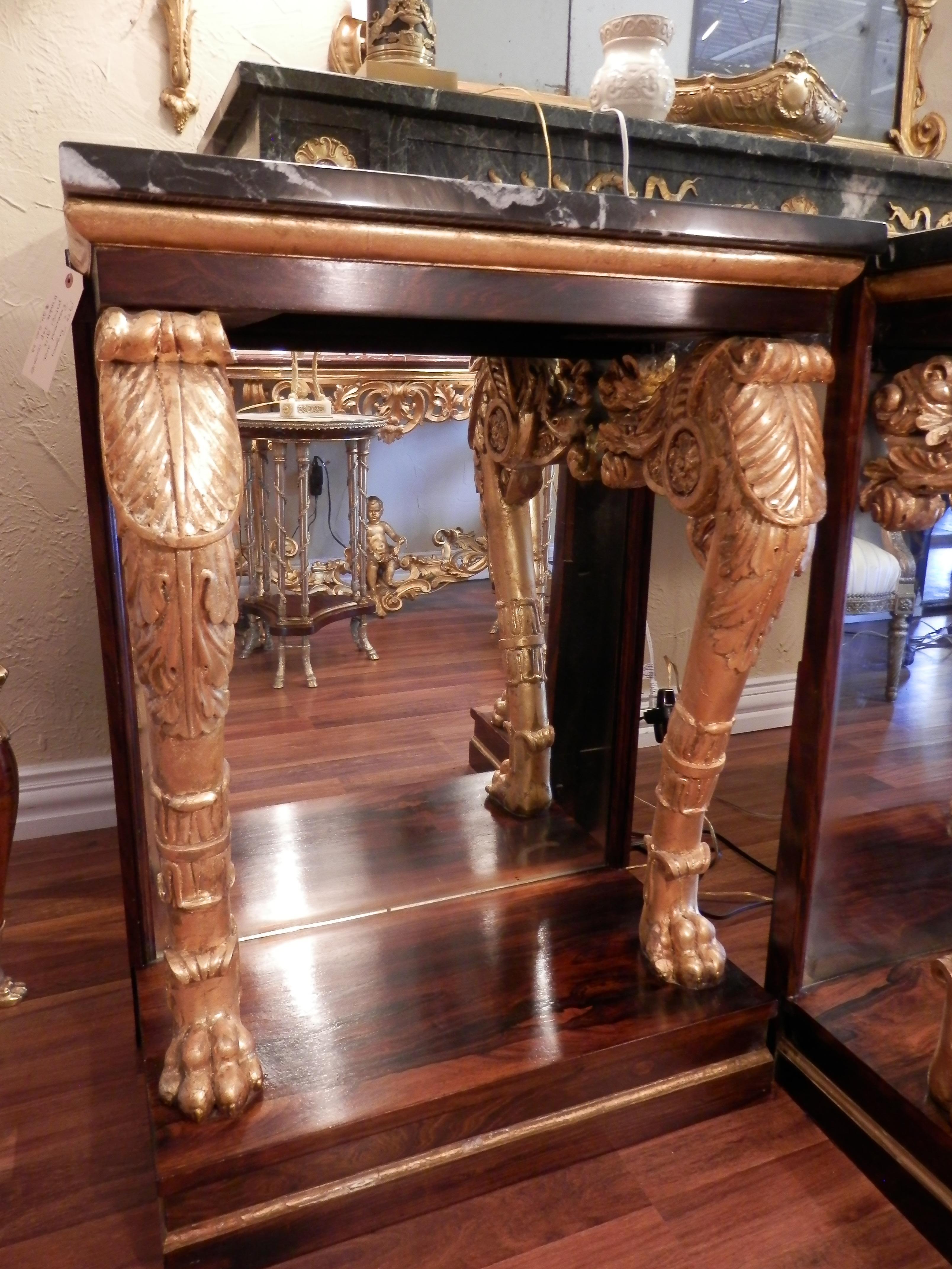 A fine pair of Regency rosewood and parcel gilt carved consoles with marble tops . Mirrored backs . Fine quality