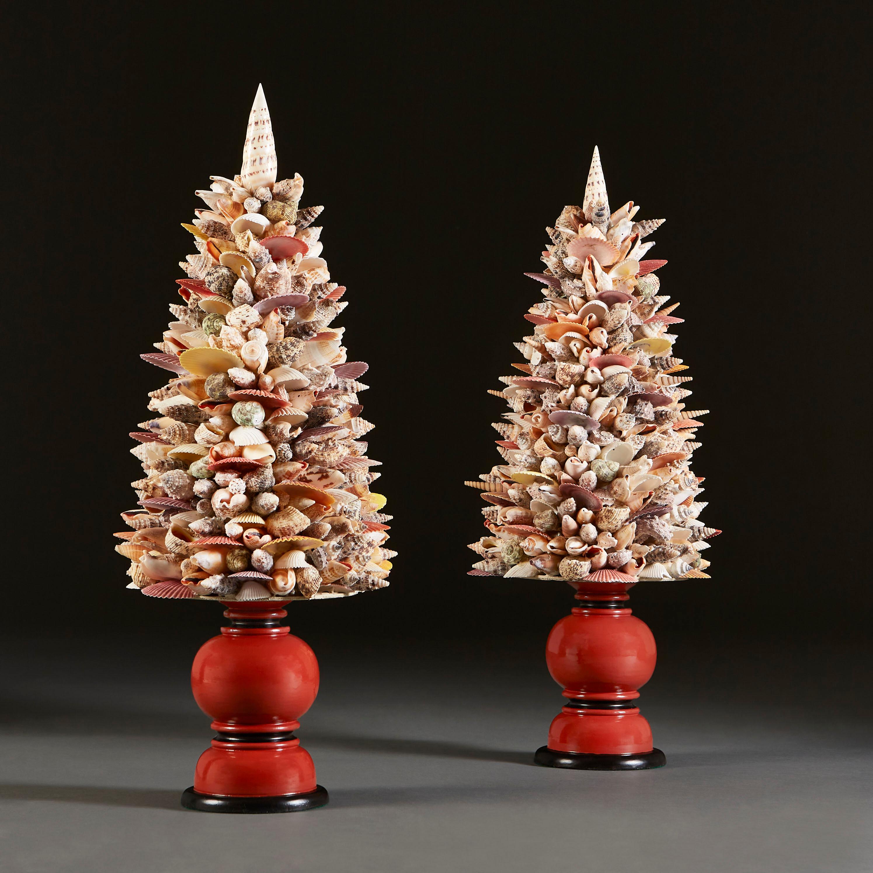 A fine pair of shell obelisks on painted, turned wood bases, with shells of various colours, and sizes forming the body of the obelisk, each topped by a white auger shell.