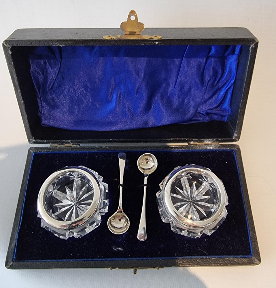 A fine pair of salt and pepper pots in silver and cut glass with spoons and in original case. Both silver hallmarked for Birmingham, 1909 date mark, makers mark H.C.D. 