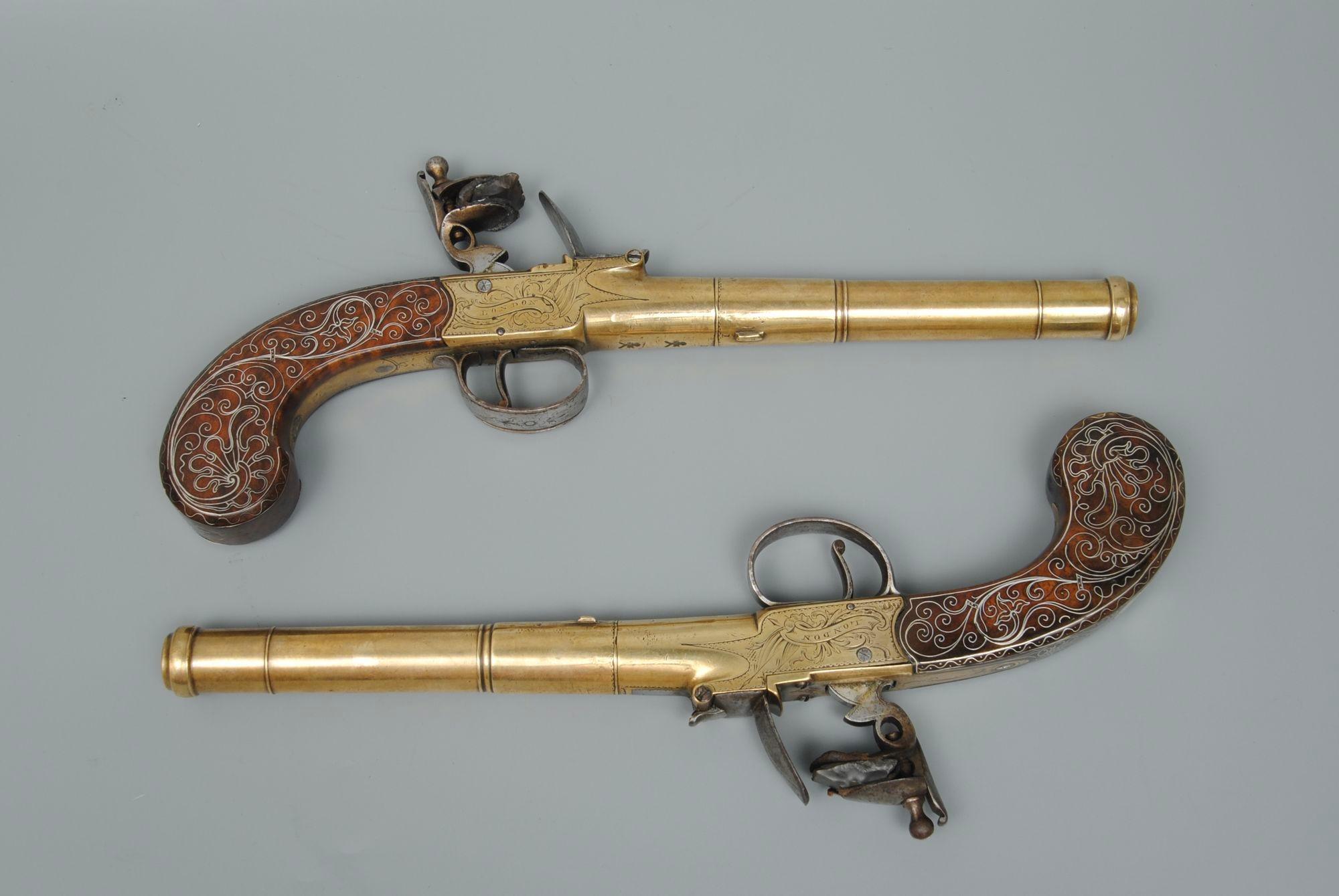A good pair of 18th century brass framed cannon barrelled turnoff pistols with fine silver wire inlaid to the walnut grips. The boxlocks with sliding safety to the trigger guards. Joseph Bunney was a fine quality maker in the second half of the 18th