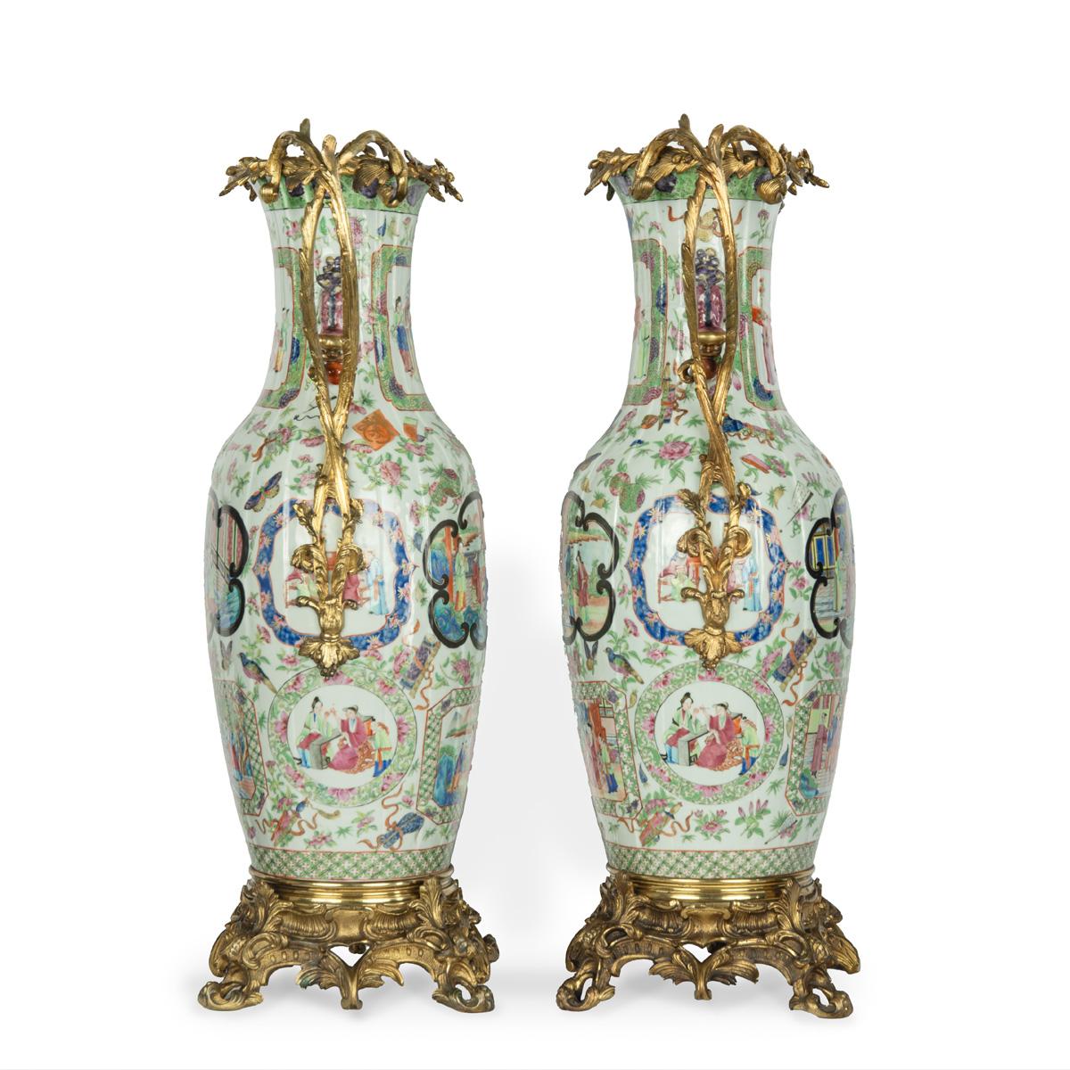 Una bella coppia di insoliti vasi in porcellana cinese con montatura in ormolu, ciascuno dipinto in smalti famille rose e dorati, di forma a balaustro con collo pieghettato e manici a forma di cane, applicati con volute di foglie in bronzo dorato