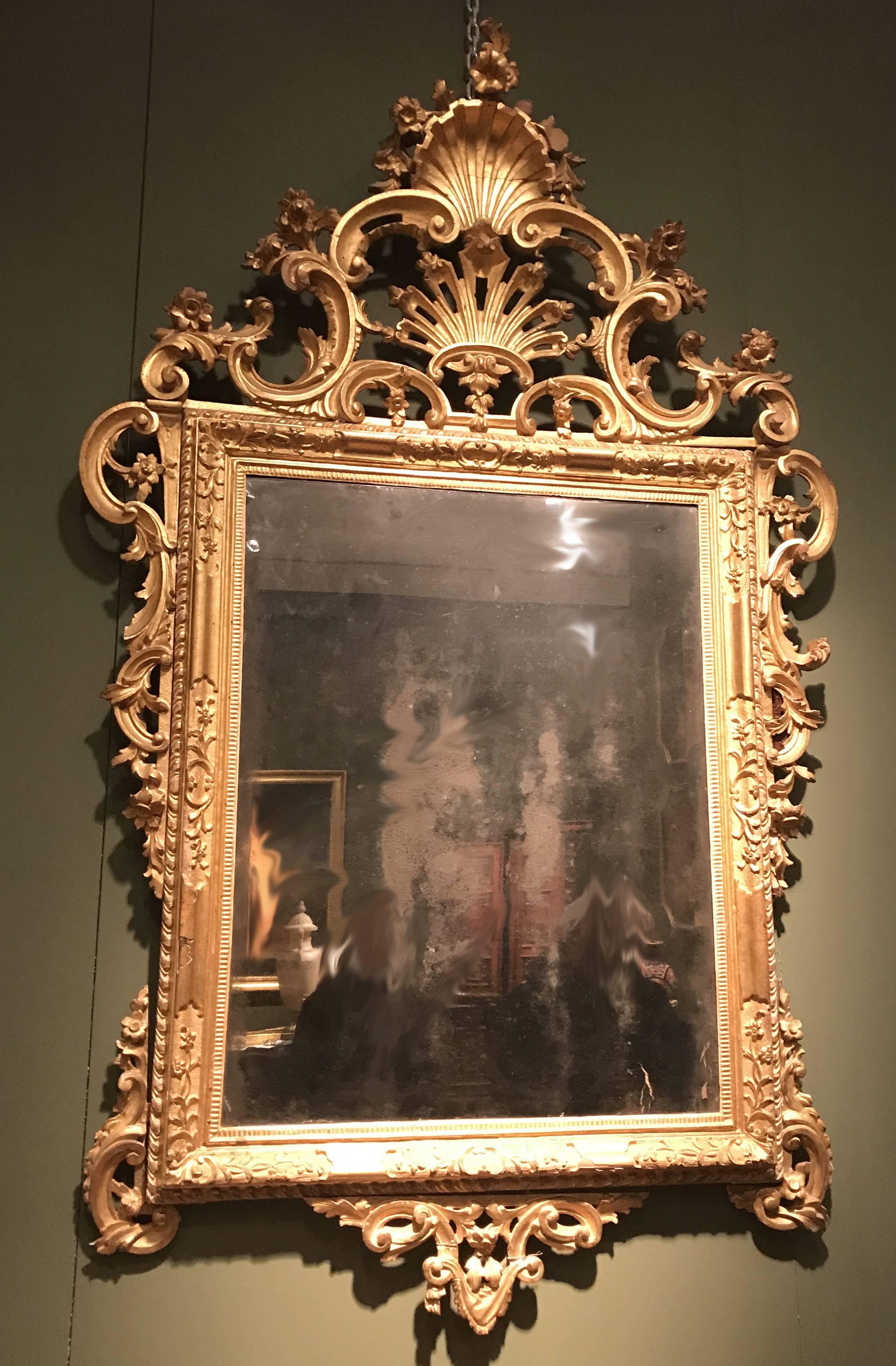 Finement sculptés à la main, les miroirs rectangulaires sont décorés d'une crête de cartouche à feuilles d'acanthe centrée par une ornementation de coquillages stylisés.
Dorure d'origine en très bon état.
Provenance d'une famille noble vénitienne.