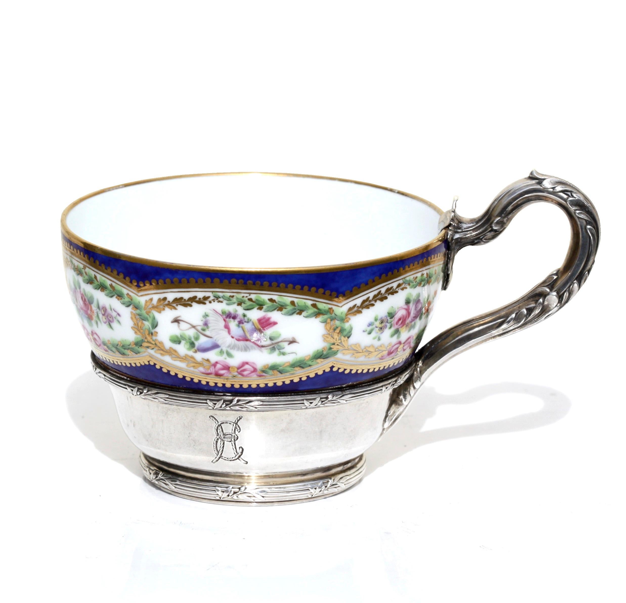 A fine porcelain silver mounted teacup and saucer, 19th century
the exteriors finely painted with colorful floral arrangements, blue printed factory marks.
Measures: Diameter of saucer 6 1/4 in.
15.2 cm.

   