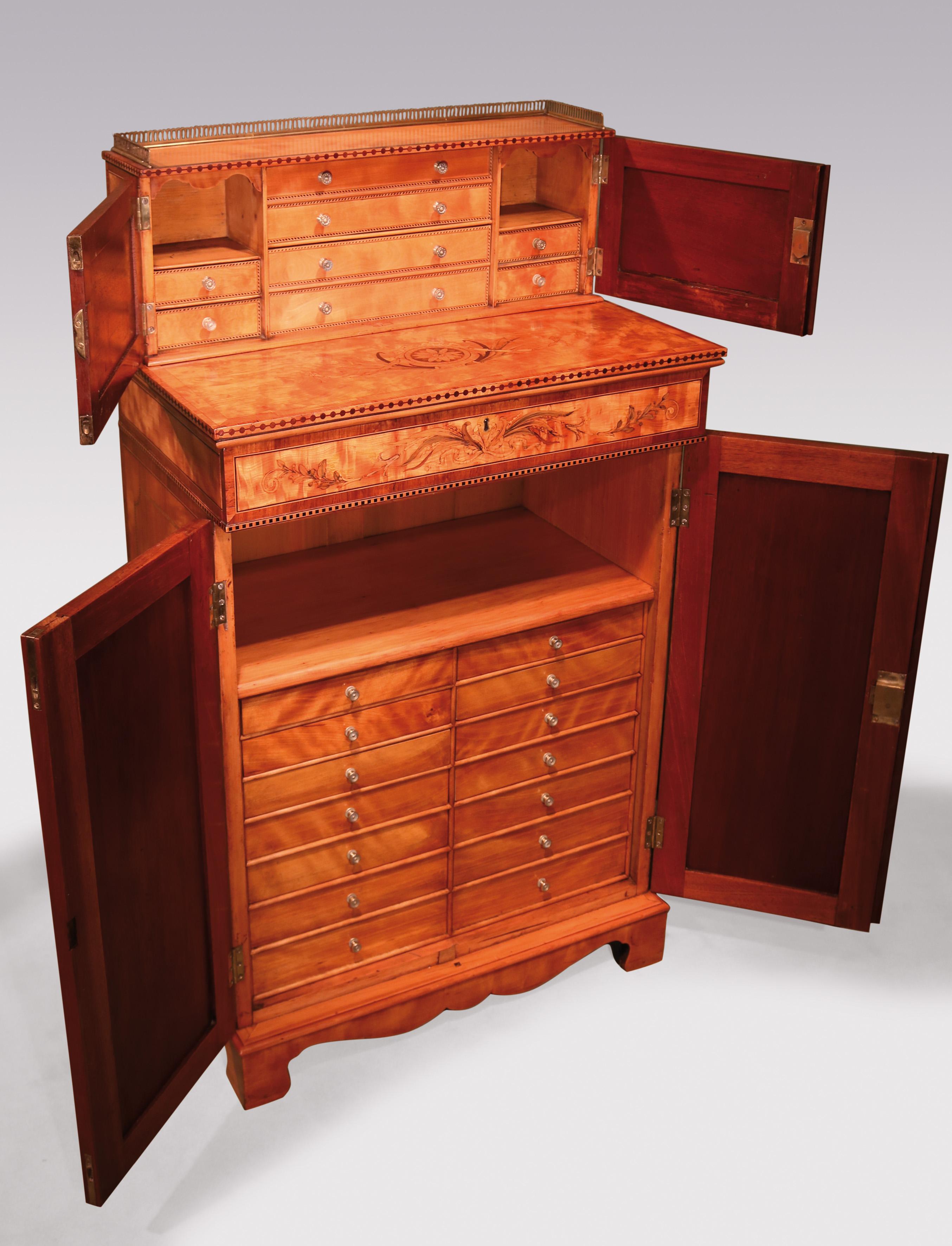 A rare late 18th century satinwood collector’s cabinet in the manner of Mayhew and Ince, tulipwood crossbanded throughout, the doors enclosing various small drawers inlaid with oval panels, swags & honeysuckle decoration. In the cupboard below there