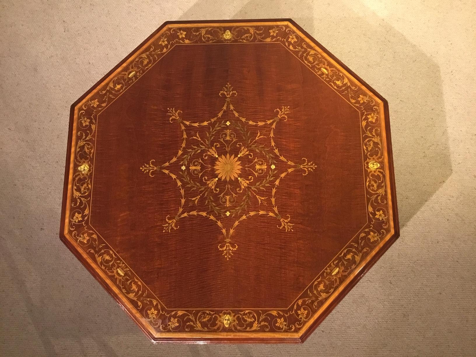 A fine quality Edwardian period octagonal marquetry inlaid table by Edwards & Roberts of London. Having an octagonal top with a superb marquetry and pen-work central panel with further marquetry and pen-work griffins etc to the border. Supported on