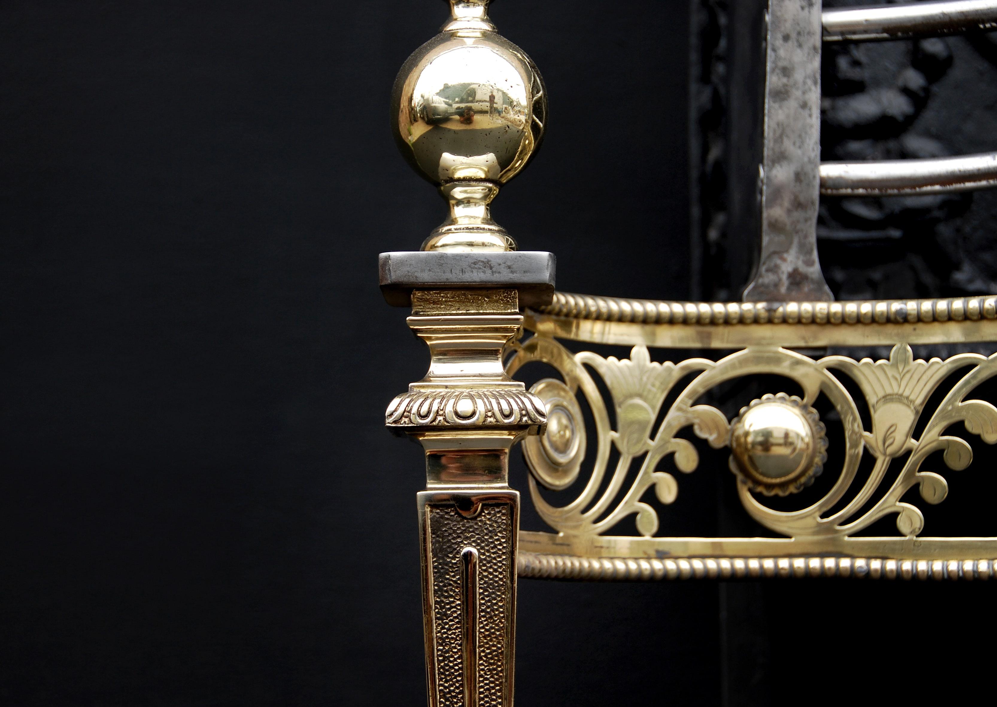 A 19th century English brass and steel firegrate with ornate fret, tapered legs surmounted by large finials and decorative fireback featuring tropical bird.

Width At Front:	763 mm      	30