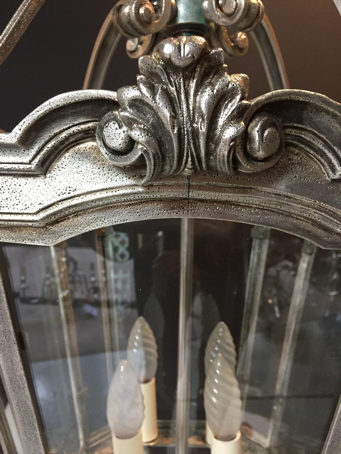 A fine quality, four light, silvered bronze hall lantern, in the Georgian style. A foliate decorated ring above an urn issuing scroll supports, canted corners and arched tapering sides with glass panels.