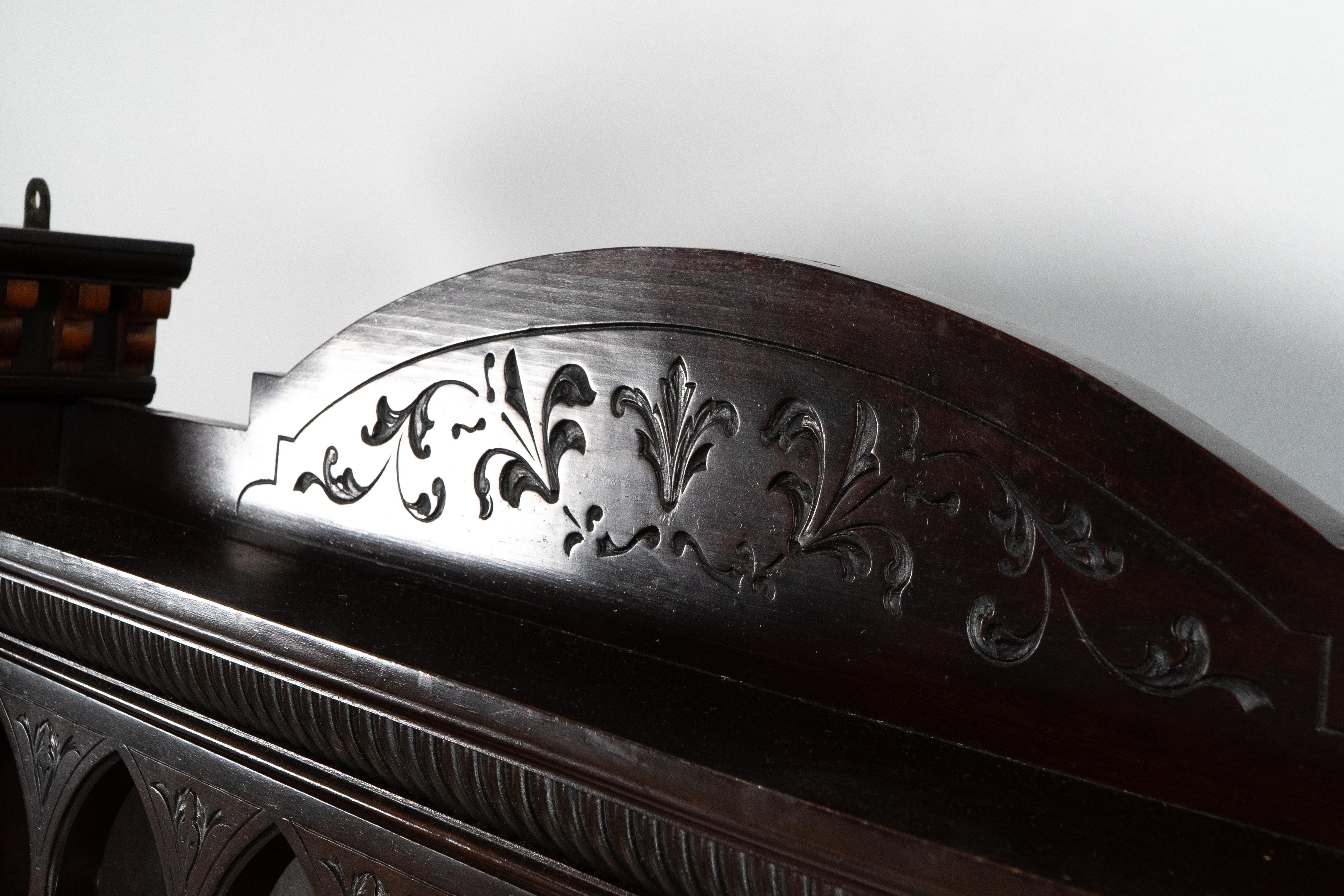 Jackson and Graham attributed. A fine quality Moorish mahogany over mantle or wall shelf, with carved floral decoration to the central upper pediment and a display shelf below. Seven central Moorish niches with carvings and mahogany and boxwood