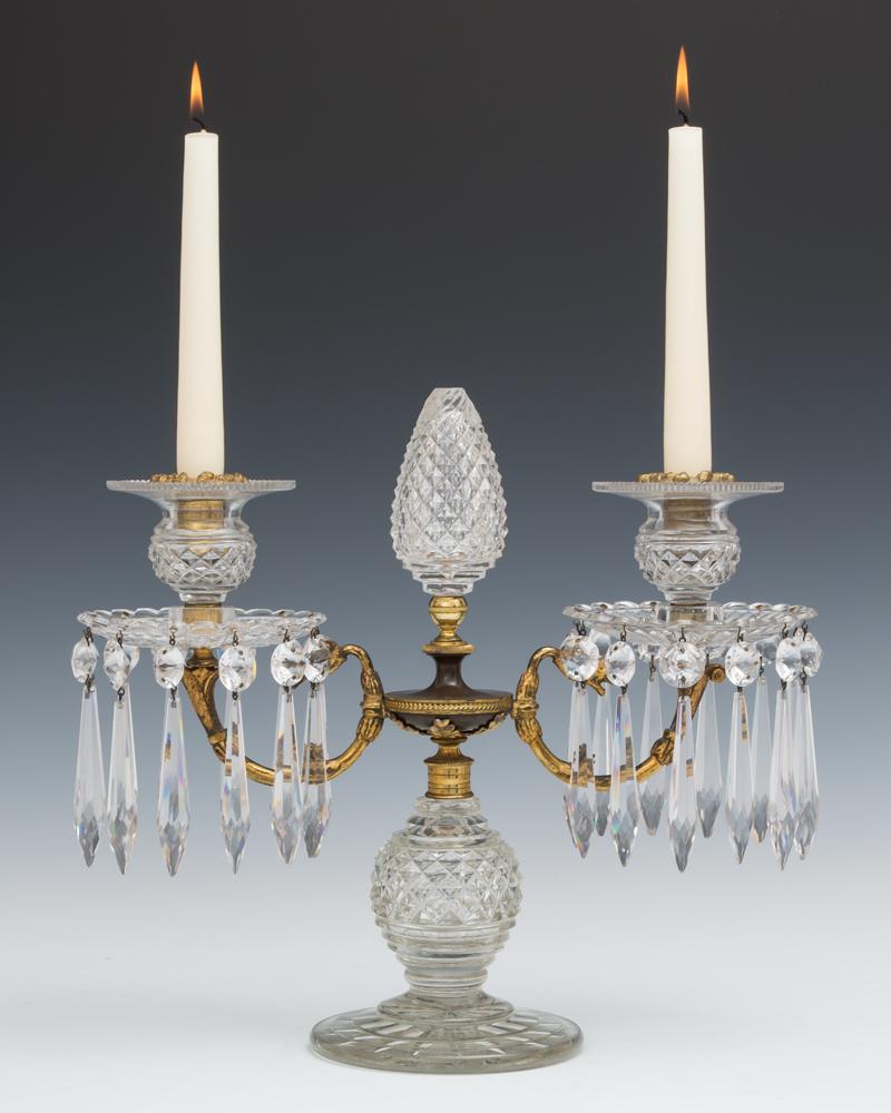 A fine quality pair of regency period cut-glass, gilt and bronzed candelabra the diamond cut base surmounted with a centre bronzed urn this urn ormolu mounted with anthemion and supporting twin candle branches this with radial cut scalloped edged