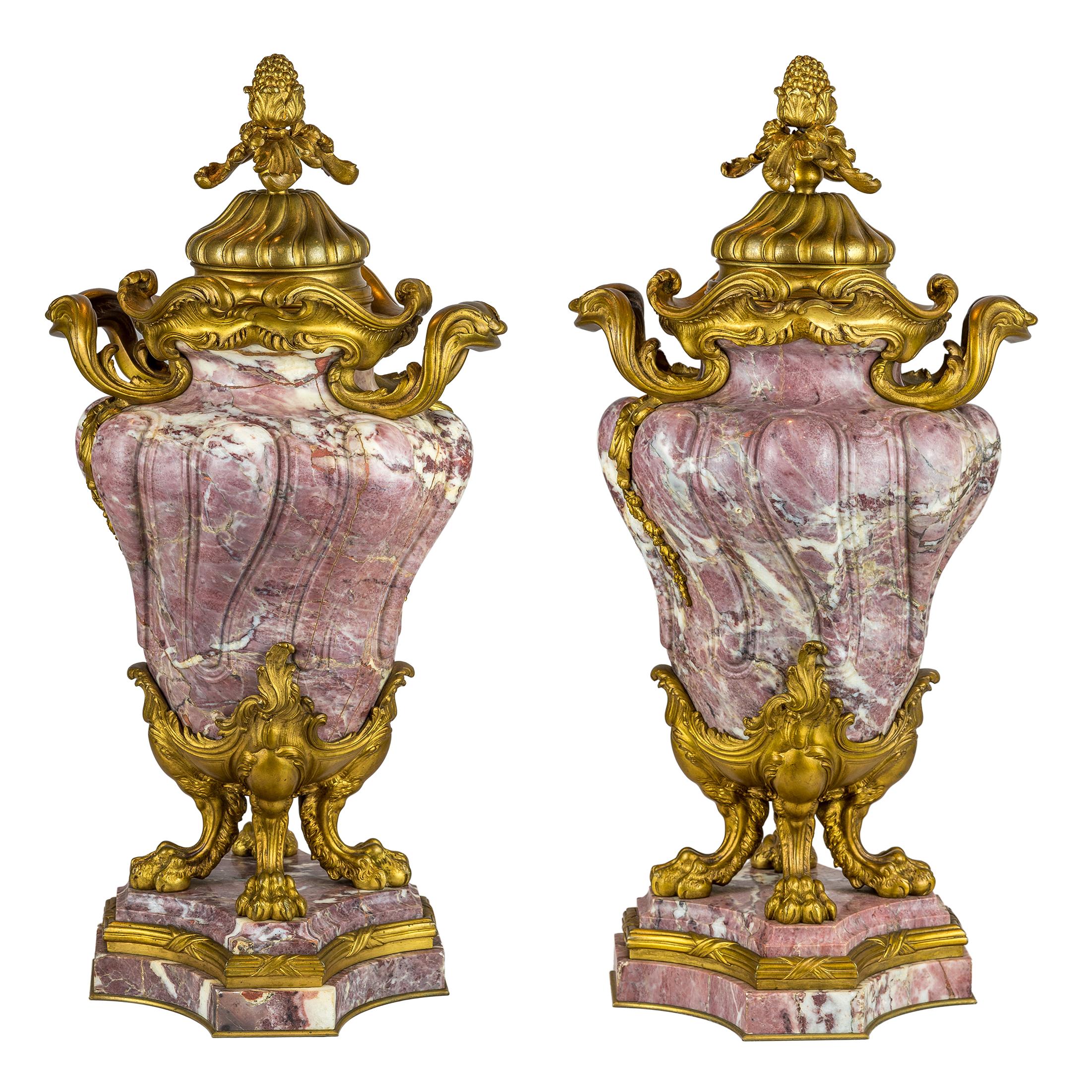 Louis XV-style Ormolu-Mounted and Fleur de Pêcher Marble Cassolets by Jollet & CIE Each with the stamp 'Jollet et Cie, Ave. Mon Colin A Paris' to the underside.

Maker: Jollet & CIE., Paris
Origin: French
Date: late 19th century
Size: 21 1/2 inches