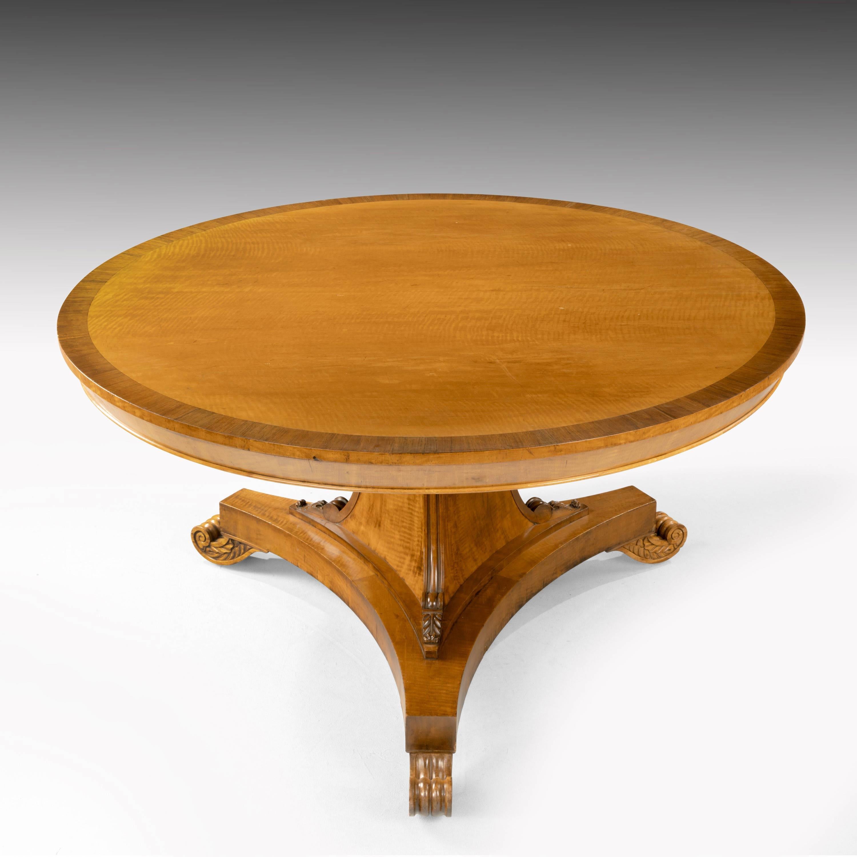 A very fine quality Regency period maple and rosewood centre table. On a strong tri-form pod with edge carving and a tri-form base. With finely carved scrolled feet. Exceptionally fine original condition.
    