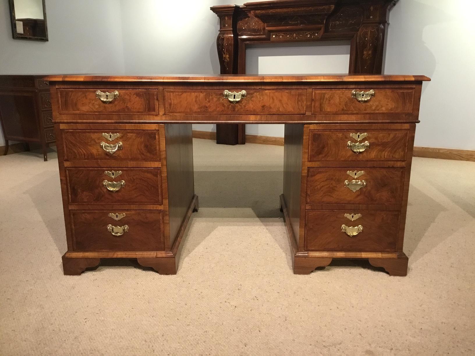 A fine quality walnut Edwardian Period partners desk in the Georgian style. Having a rectangular top having an antiqued brown leather writing surface with gilt and blind tooled detail. The top having figured walnut banding and block moulding. The