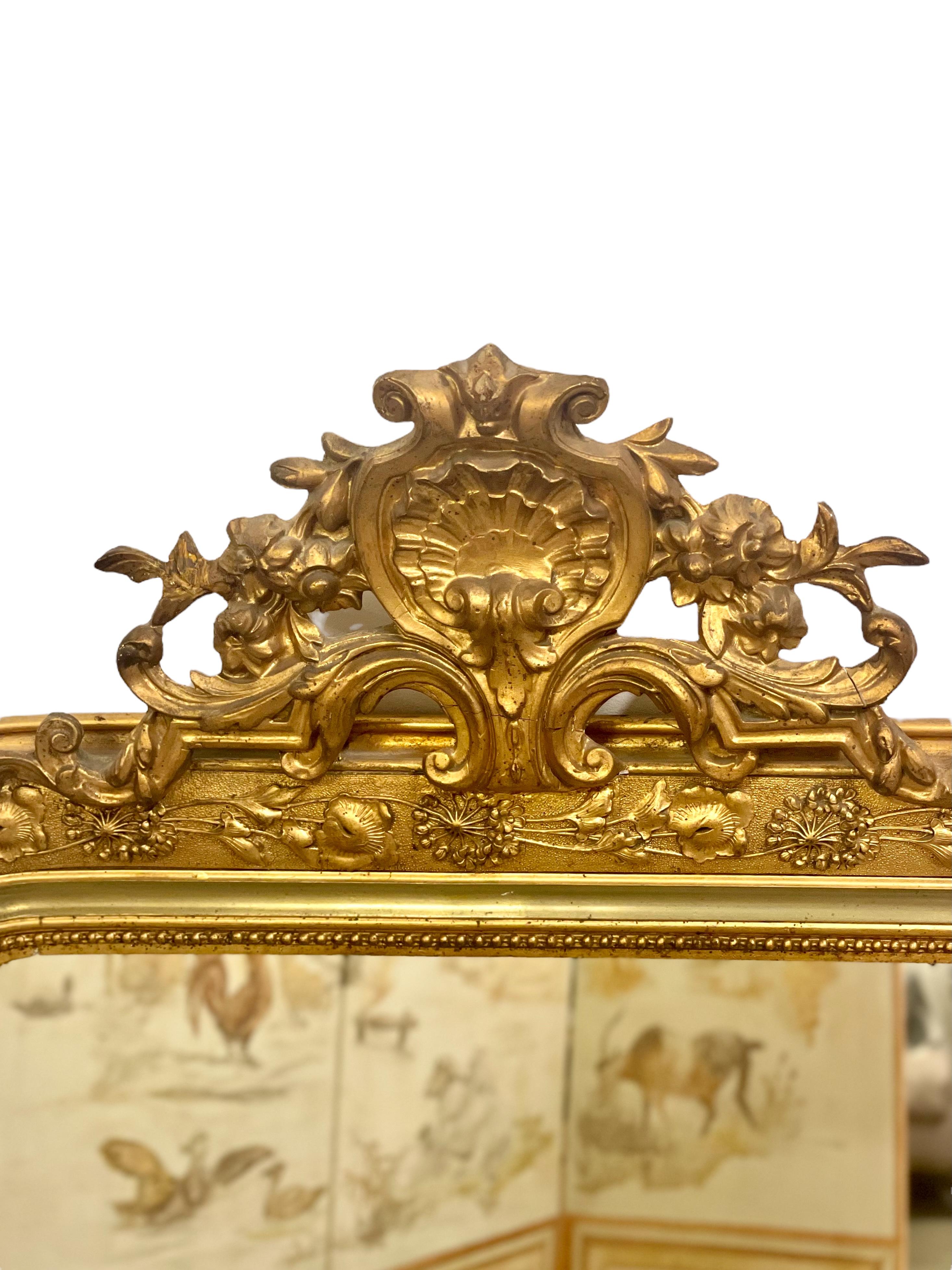A very ornate late 19th century rectangular mirror, with rounded upper corners in the Louis Philippe style. An openwork crest of acanthus leaves rises above the frame, which itself is beautifully decorated with a repeating design of intricately