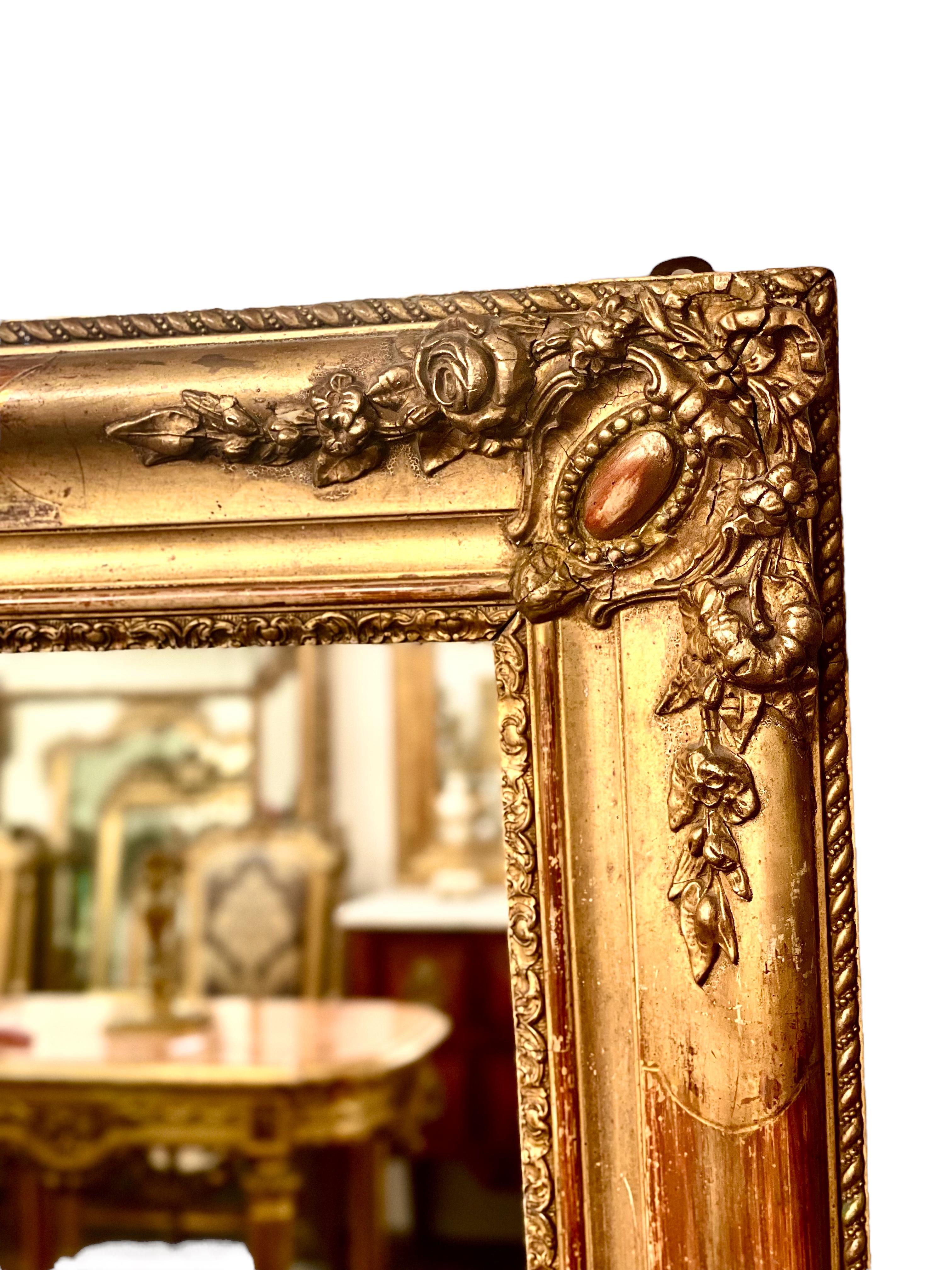 A fine rectangular Napoleon III full length mirror, in gilded wood and moulded plaster, which can be positioned horizontally or vertically. This characterful old mirror has intricate relief designs at each corner and on its long sides, with a
