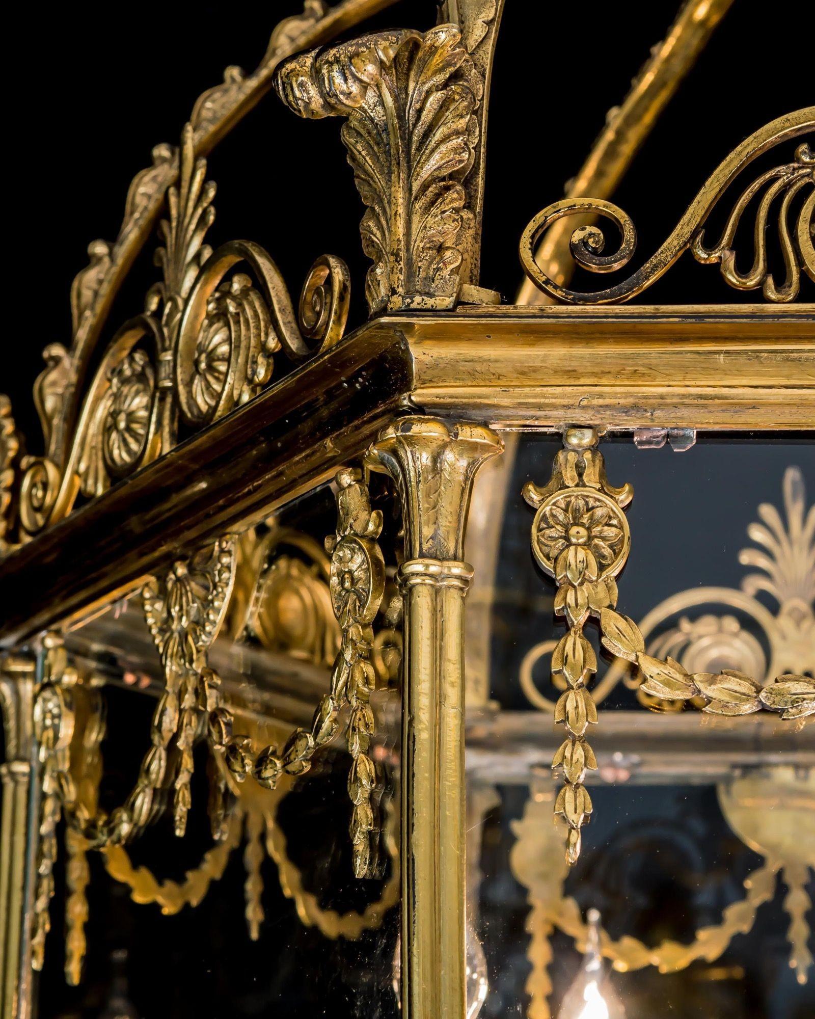 The hexagonal frame of column supports is decorated with fretted motifs, anthemions, foliated swages and scrolls, all supporting a glass cowl with folded rim. The lantern fitted with a five light candelabra.