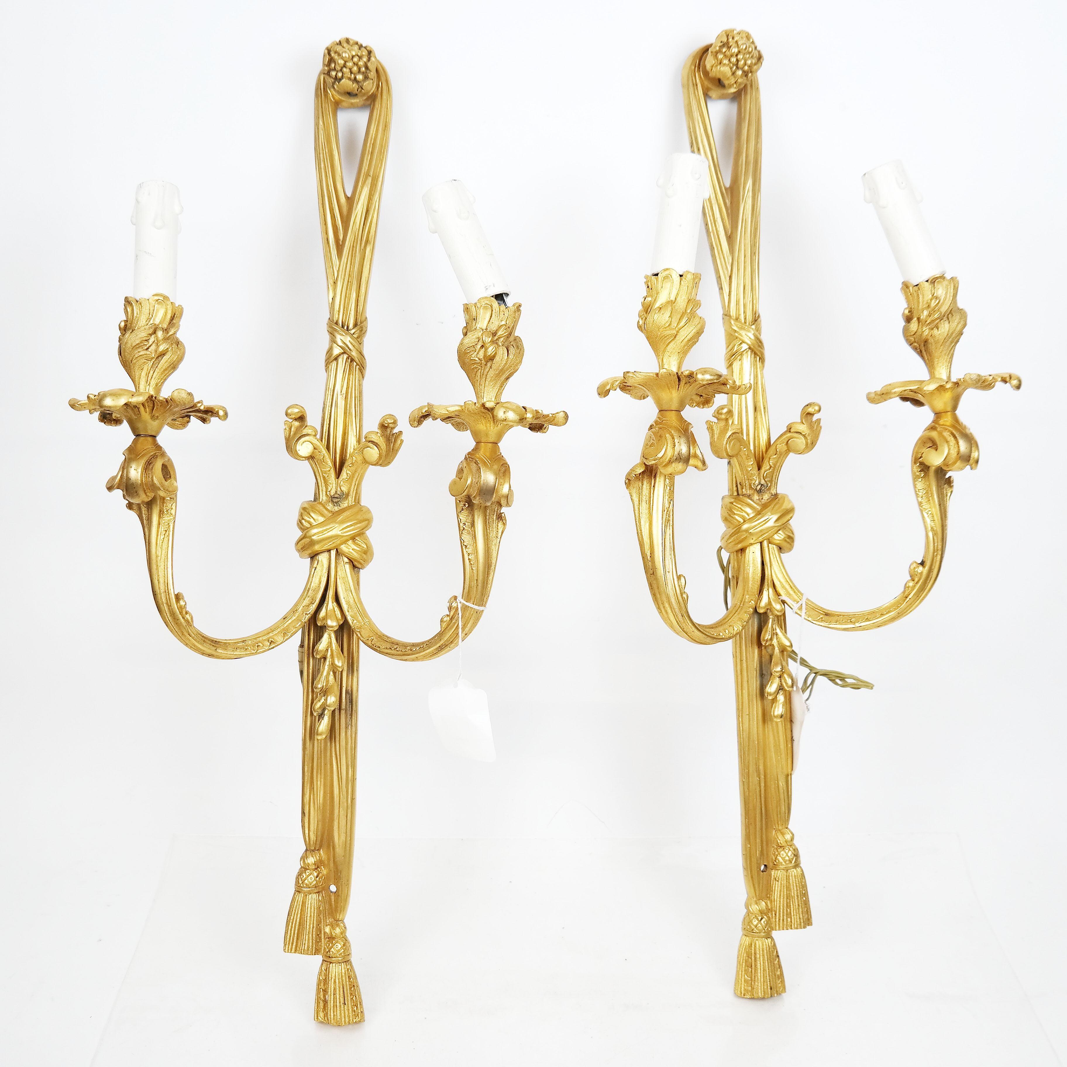 A set of 4 fine 19th century French gilt bronze sconces, having grape cluster finials on ribbon and tassel backs, with scrolling arms with flared bobeches and floral cups. [27