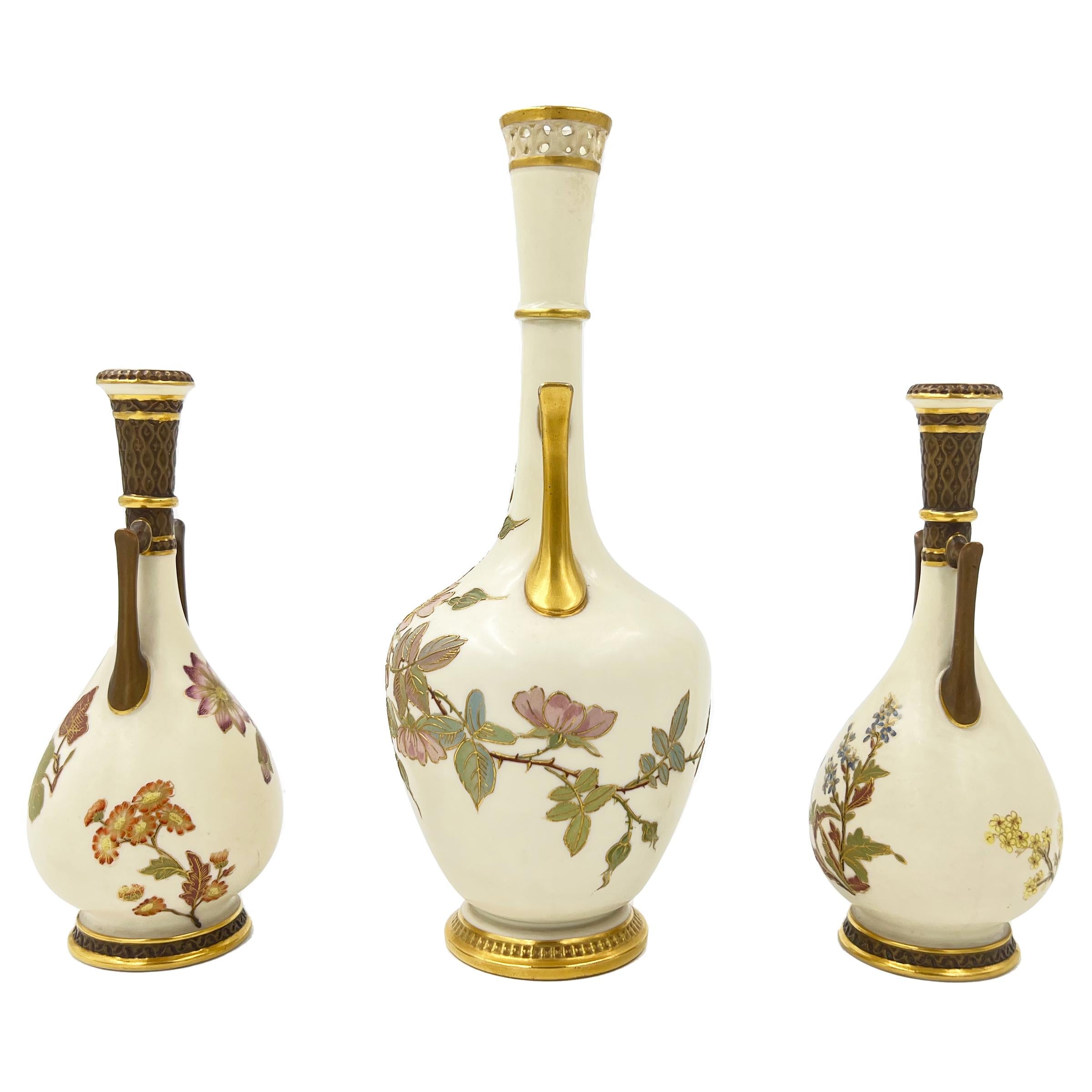 The ovoid body on each vase decorated with gilded floral design, the ovoid body attached to a long neck with two side handles, raised on circular gilded bases, stamped on the base of each vase. 

Dimensions: large vase: 25cm, diameters:
