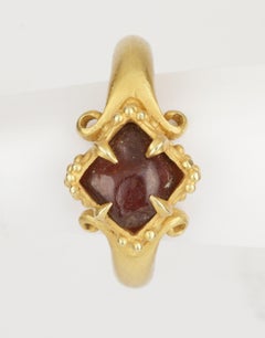 A Fine Temple Ring Set with a Rough Garnet and Raised, Lobed Bezel