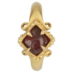 A Fine Temple Ring Set with a Rough Garnet and Raised, Lobed Bezel