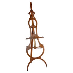 A fine Victorian brown oak and marquetry easel of elegant scrolled form