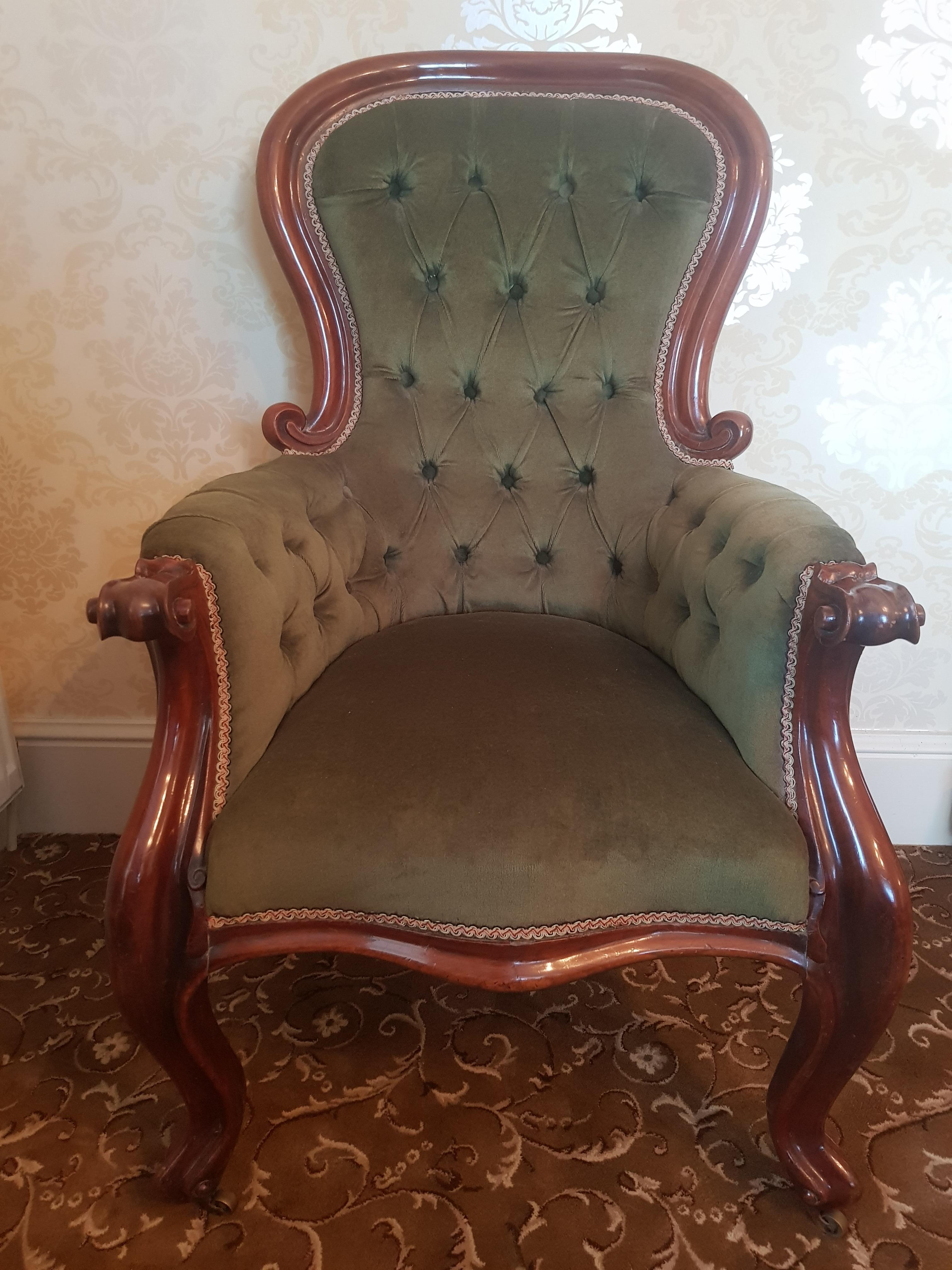 A fine Victorian mahogany gentleman's armchair or Parlor chair, with rounded buttoned back, finely carved cabriole legs terminating on original brass castors. Upholstered in good quality sofa fabric.

With accompanying foot rest.