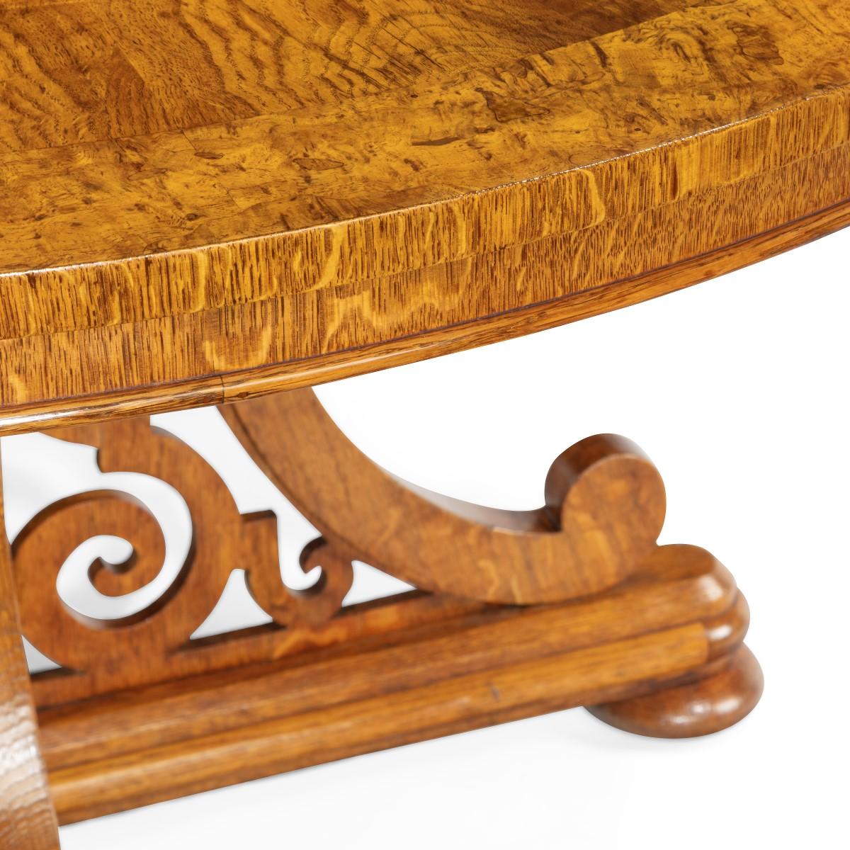 A fine Victorian pollard oak centre table, in the manner of Bridgens, the circular top with radiating flame veneers set upon a cluster of pillars, flanked by four large C-scroll supports enclosing S-scroll openwork panels, all on a cruciform base