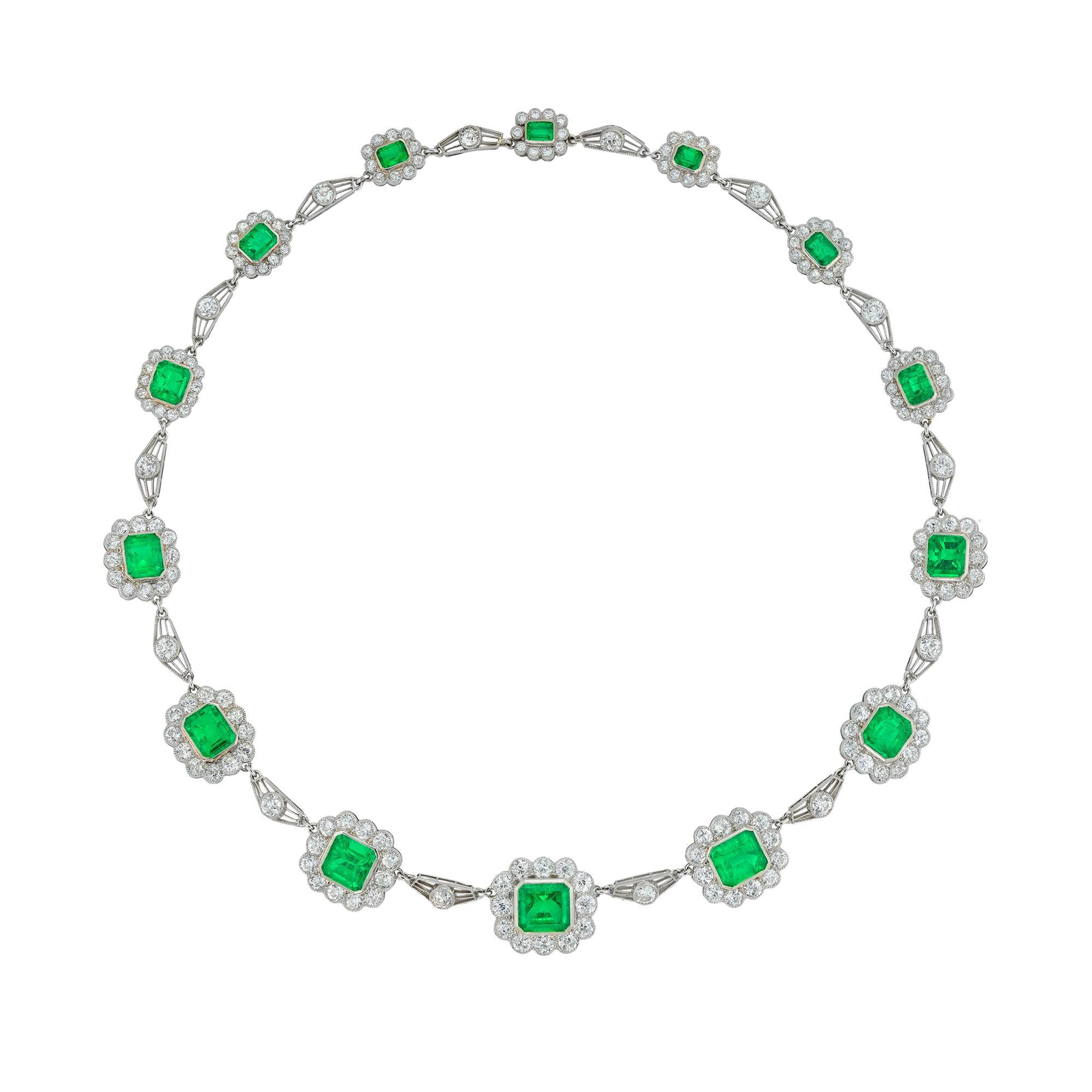 A fine Vintage emerald and diamond necklace, the fourteen octagonal-cut emeralds estimated to weigh 17 carats in total, the ten larger of Colombian origin, each surrounded by scalloped-edge frame set with old European-cut diamonds, connected with