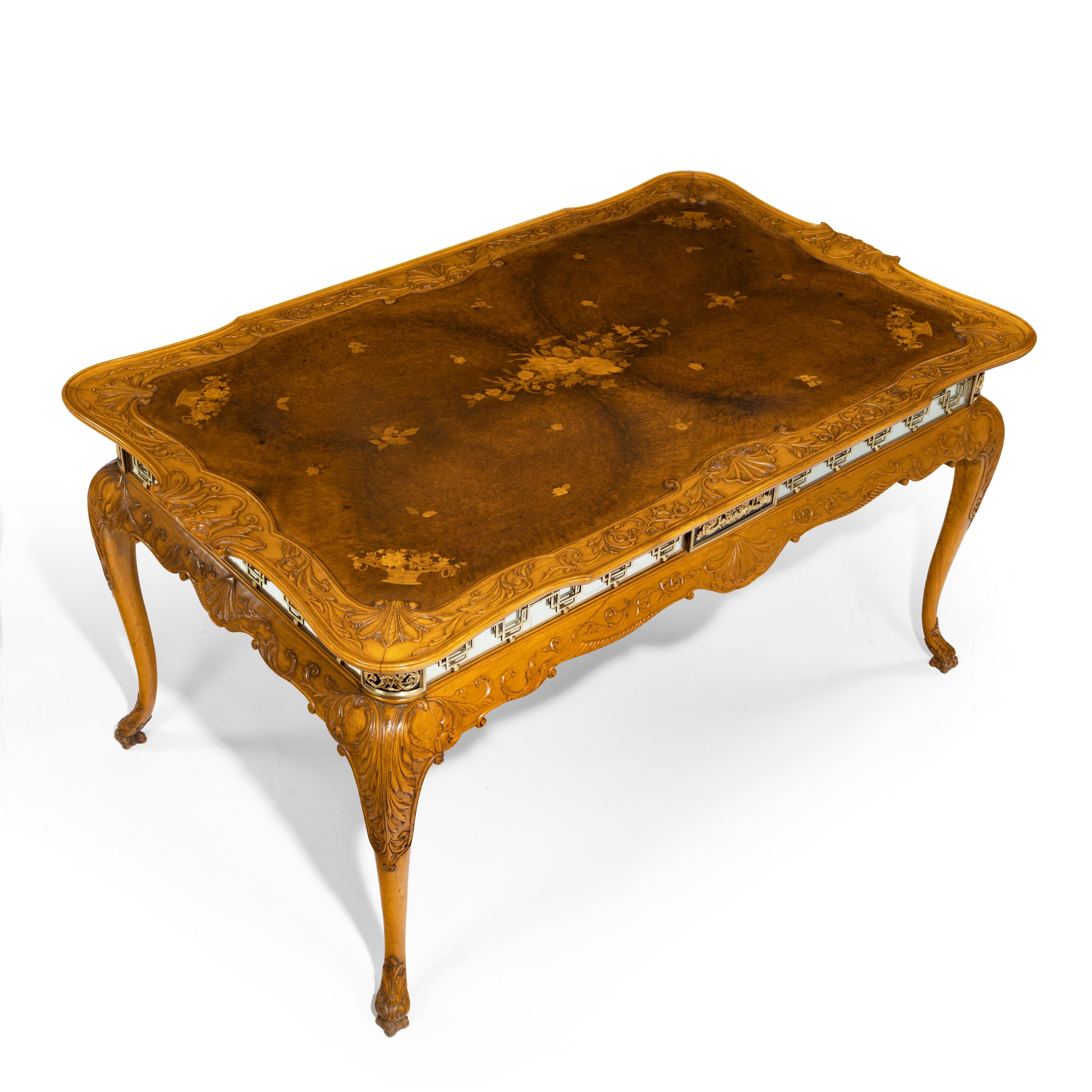 A fine walnut and burr walnut orientalist centre table, of shaped rectangular form with a mirrored frieze, set upon carved cabriole legs terminating in acanthus feet, decorated with quarter veneered top inlaid in boxwood with scattered flower heads
