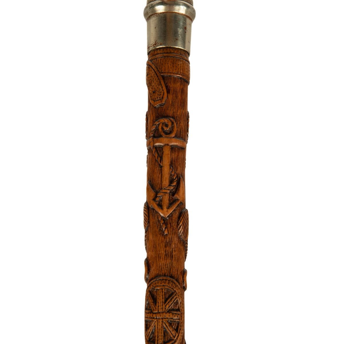 A finely carved fruitwood cane with royal and masonic symbols, the pokerwork handle made to resemble tortoiseshell, with a nickel band, the shaft profusely and meticulously carved with three sections comprising firstly a crown and anchor, Prince of