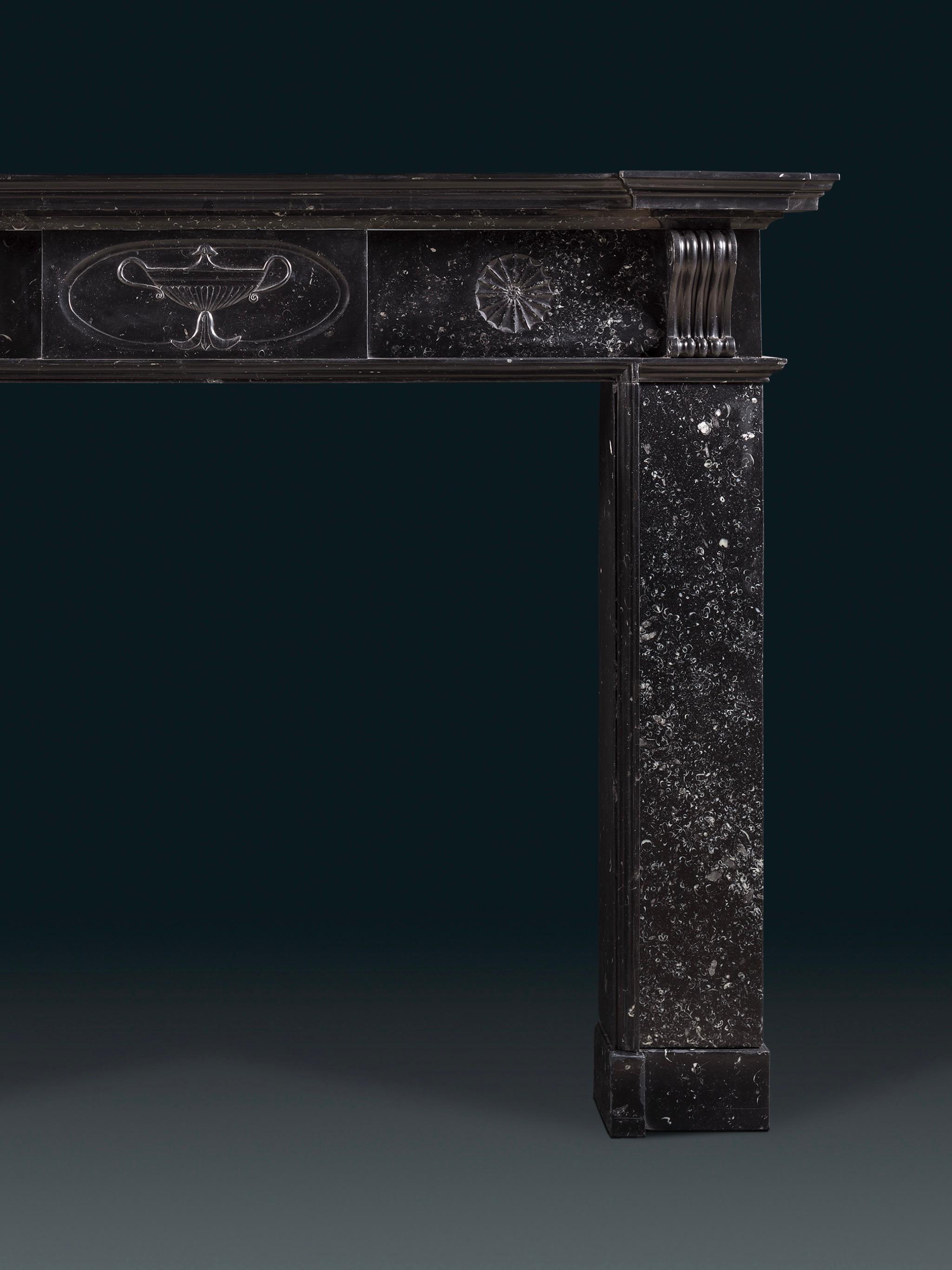 Cheminée irlandaise en marbre de Kilkenny d'époque George III, finement sculptée à la manière de Charles Robert Cockerell.

La tablette centrale est sculptée d'un motif de tazza romain, popularisé par Robert Adams, flanquée de corbeaux à volutes en
